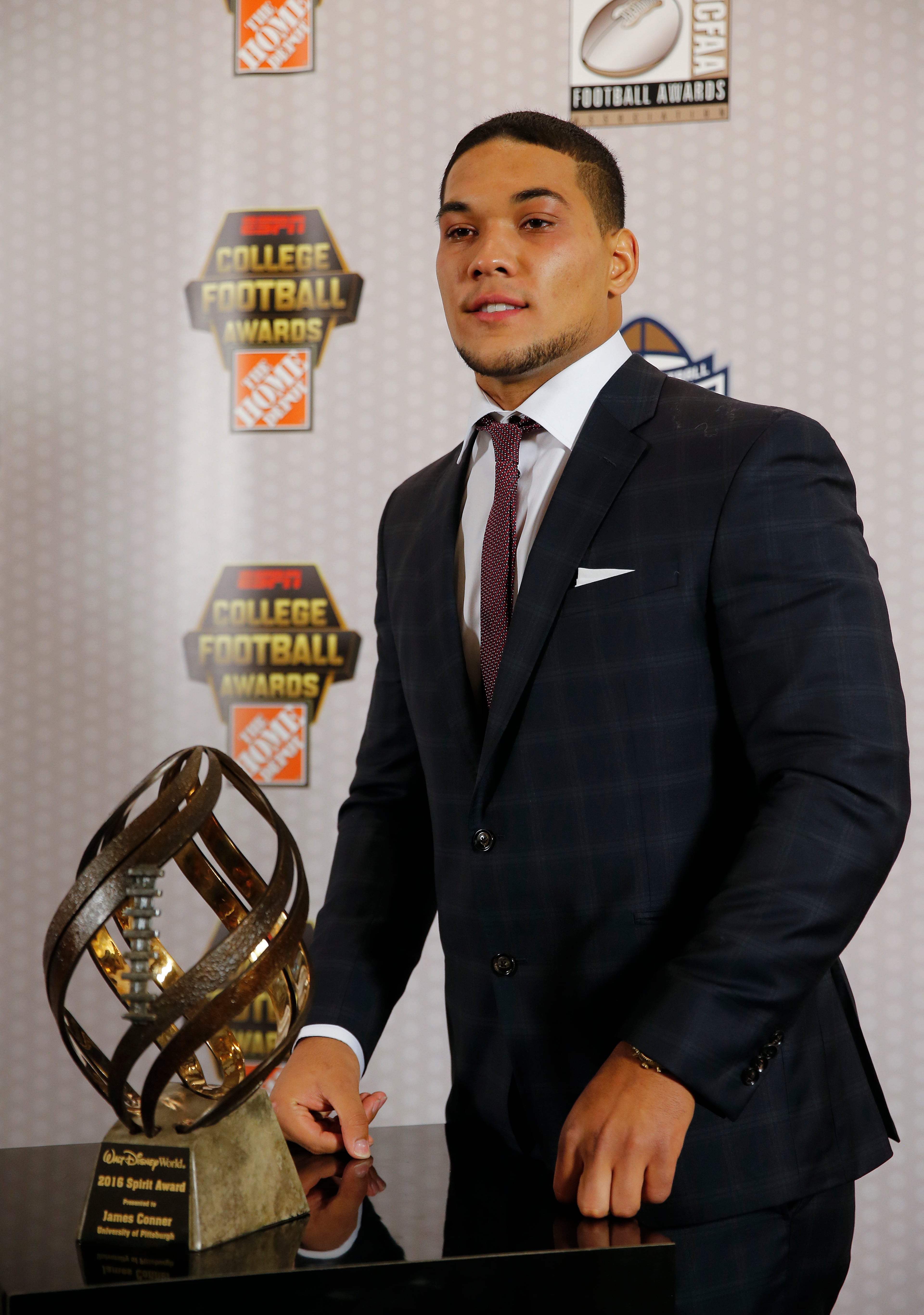 Pittsburgh running back and cancer survivor James Connor poses with the trophy after winning the Disney Spirit Award for most inspirational college football player Thursday, Dec. 8, 2016, in Atlanta. (AP Photo/John Bazemore)