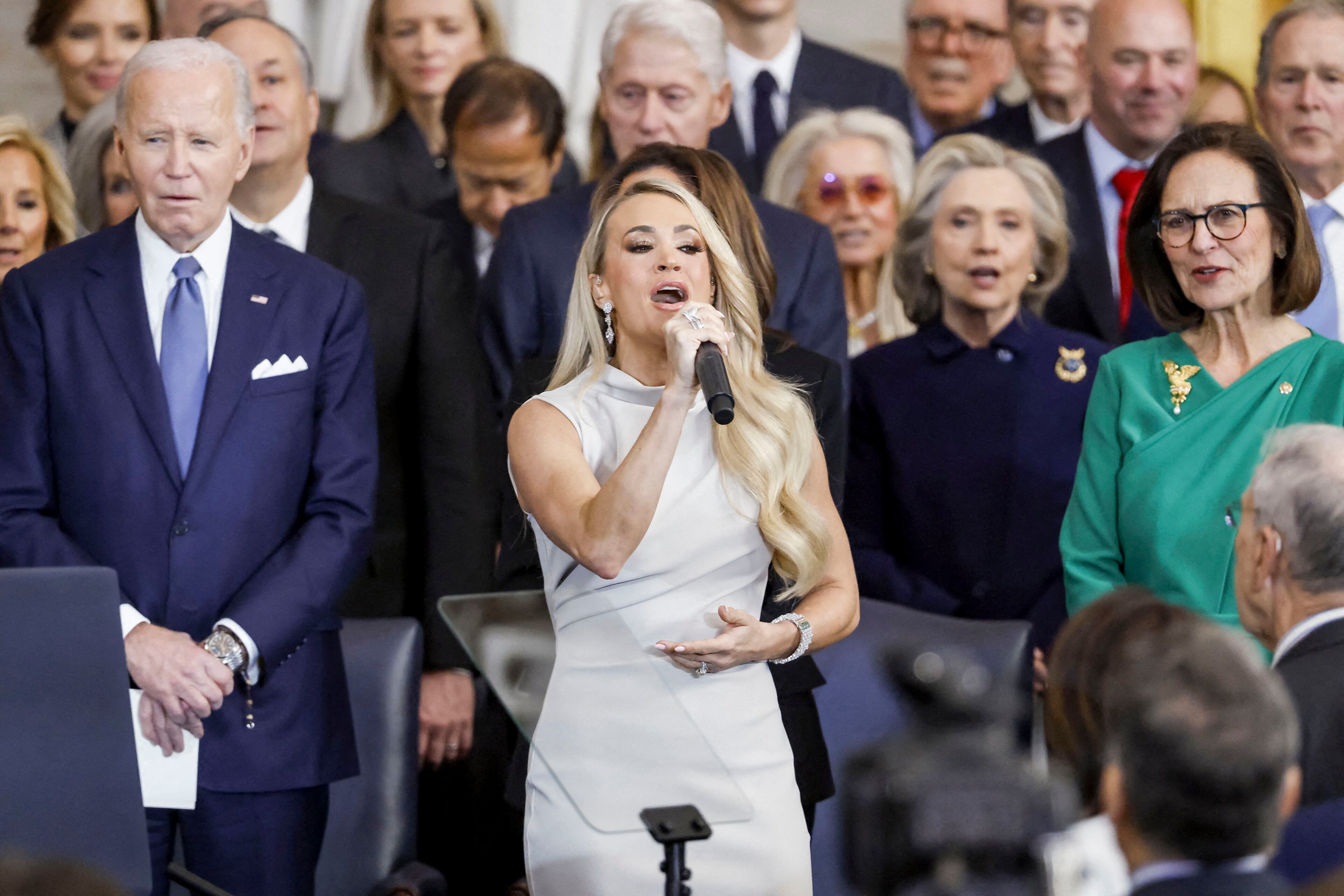 Former President Joe Biden (left) looks on as country singer Carrie Underwood (center) performs during the inauguration ceremony in Washington on Monday. Before his term, expired Biden moved to ban new offshore drilling in most U.S. coastal waters.