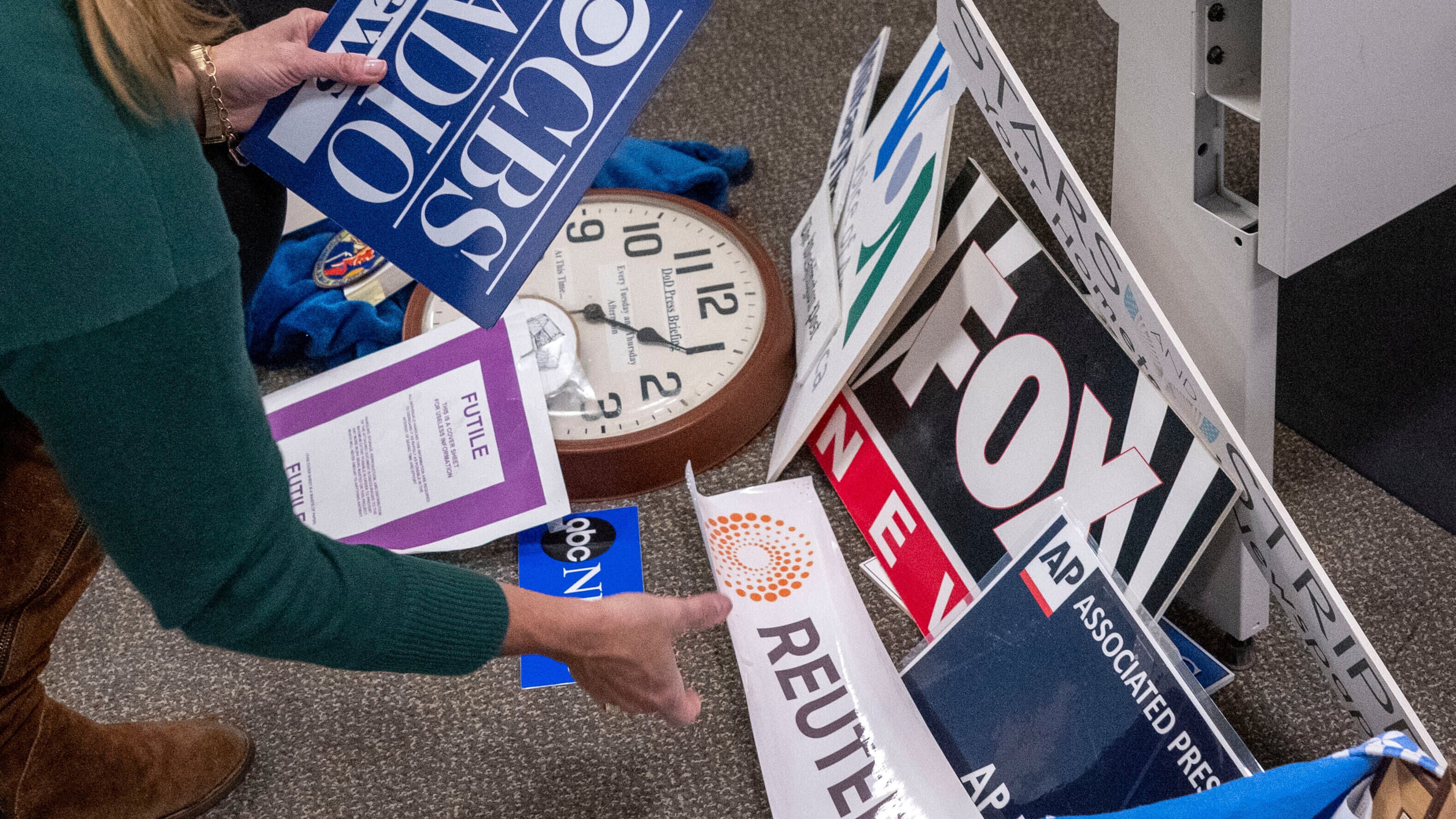 FILE - Washington Post reporter Tara Copp saves the name plaques from various news organizations as she and members of the media pack up their belongings in the press area in the Pentagon, Oct. 15, 2025 in Washington. (AP Photo/Kevin Wolf, File)