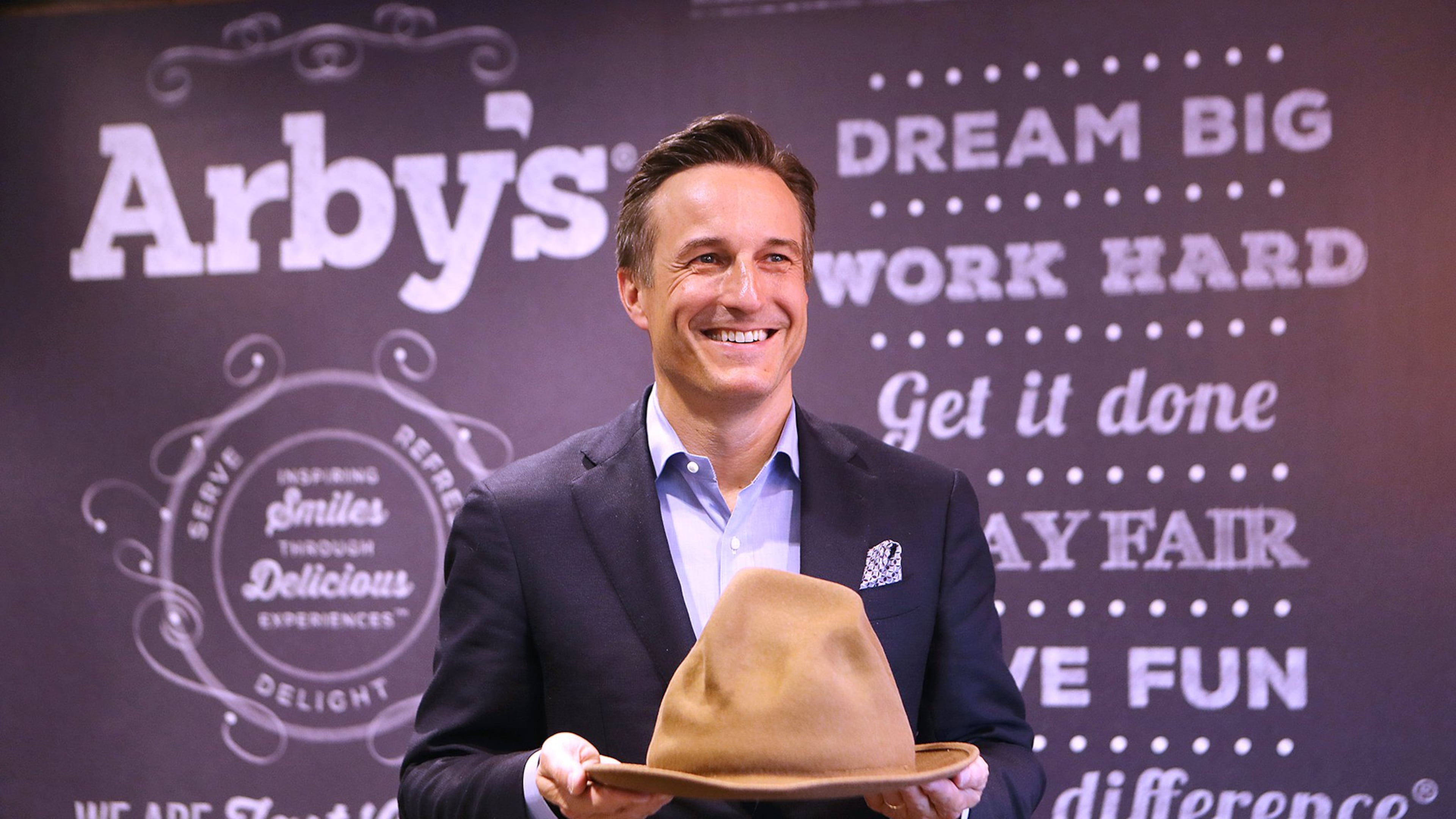 Arby’s CEO Paul Brown, holding a hat Pharrell Williams wore during the 2014 Grammy Awards, says playful products and marketing have paid off for the Atlanta fast-food chain. The hat, which Arby’s bought for $49,000, resembles Arby’s logo. Curtis Compton/ccompton@ajc.com