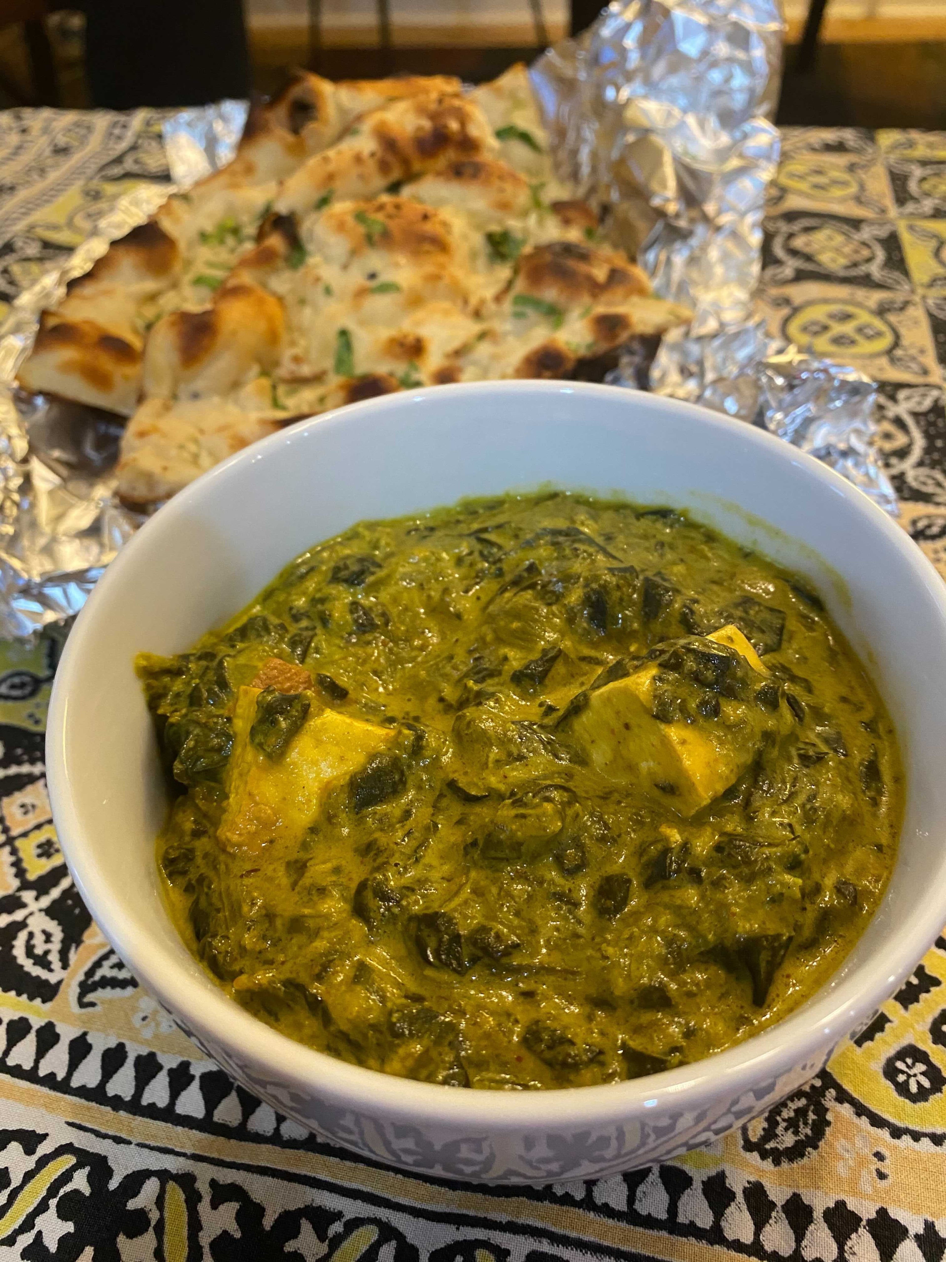 Saag paneer (foreground) and garlic naan are among the offerings at Royal Spice. Ligaya Figueras/ligaya.figueras@ajc.com