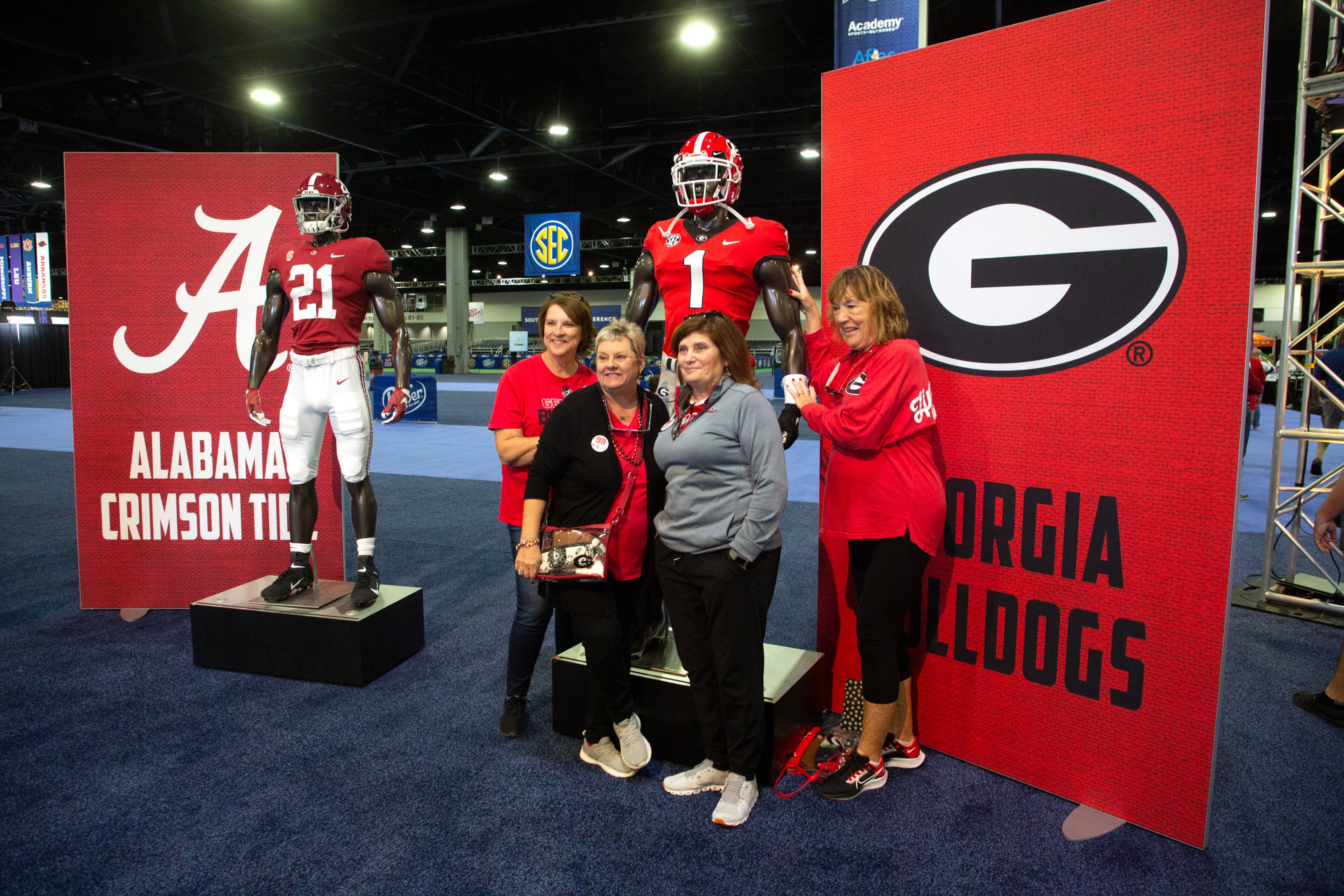 People pose by the Georgia Bulldog mannequin as they enter the world Congress Center for the SEC FanFare on Friday December 3, 2021. STEVE SCHAEFER FOR THE ATLANTA JOURNAL-CONSTITUTION