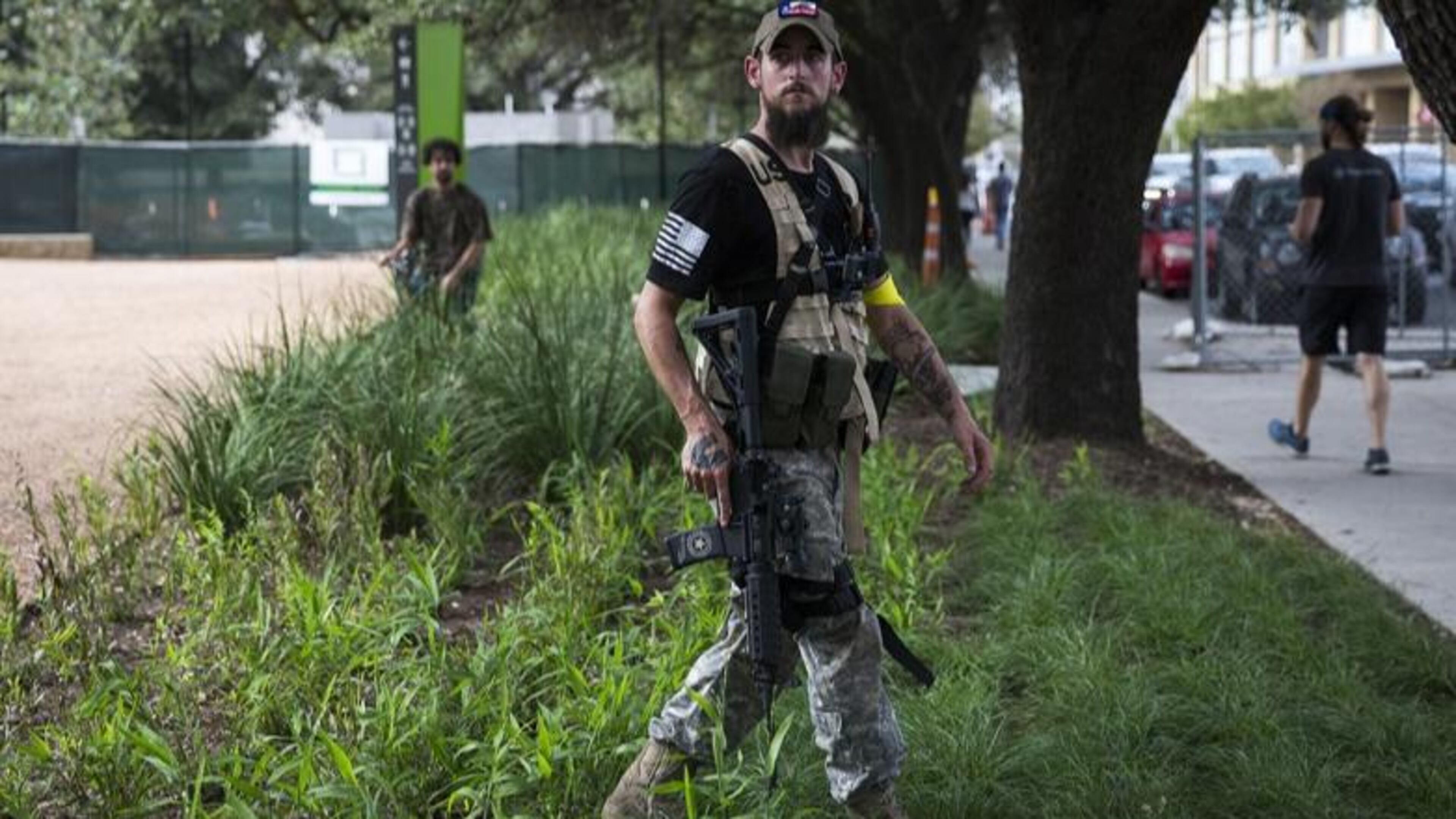 A man openly carrying a long gun walks through plants while watching anti-fascists during a demonstration in downtown Austin, Texas, on Saturday, Nov. 4, 2017. (Photo: Nick Wagner/Austin American-Statesman)
