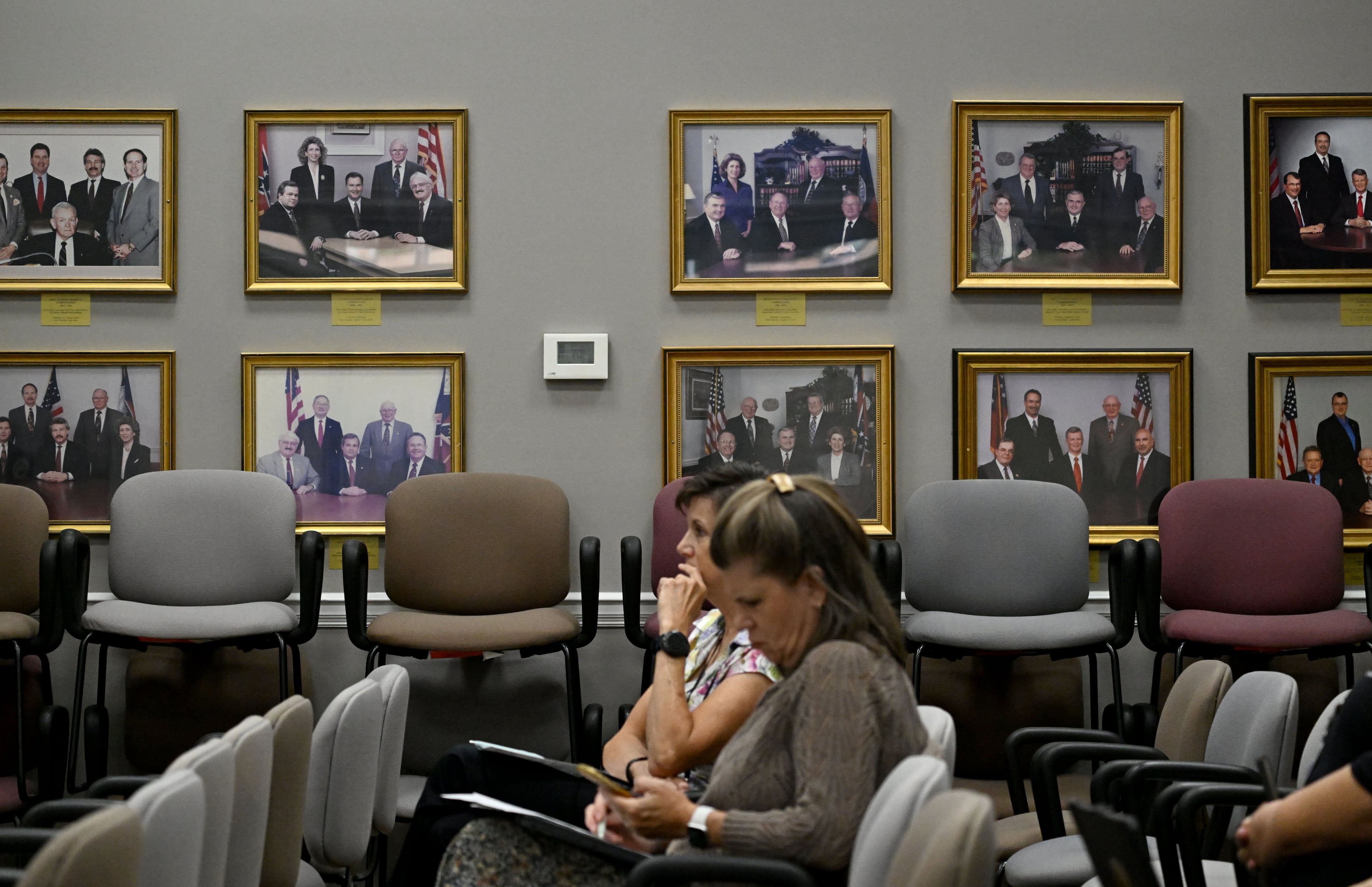 Framed group photographs of past Fayette County commissioners line the wall at the Fayette County Administrative Complex as seen during a commission meeting Thursday, Aug. 13, 2026, in Fayetteville. (Hyosub Shin/AJC)