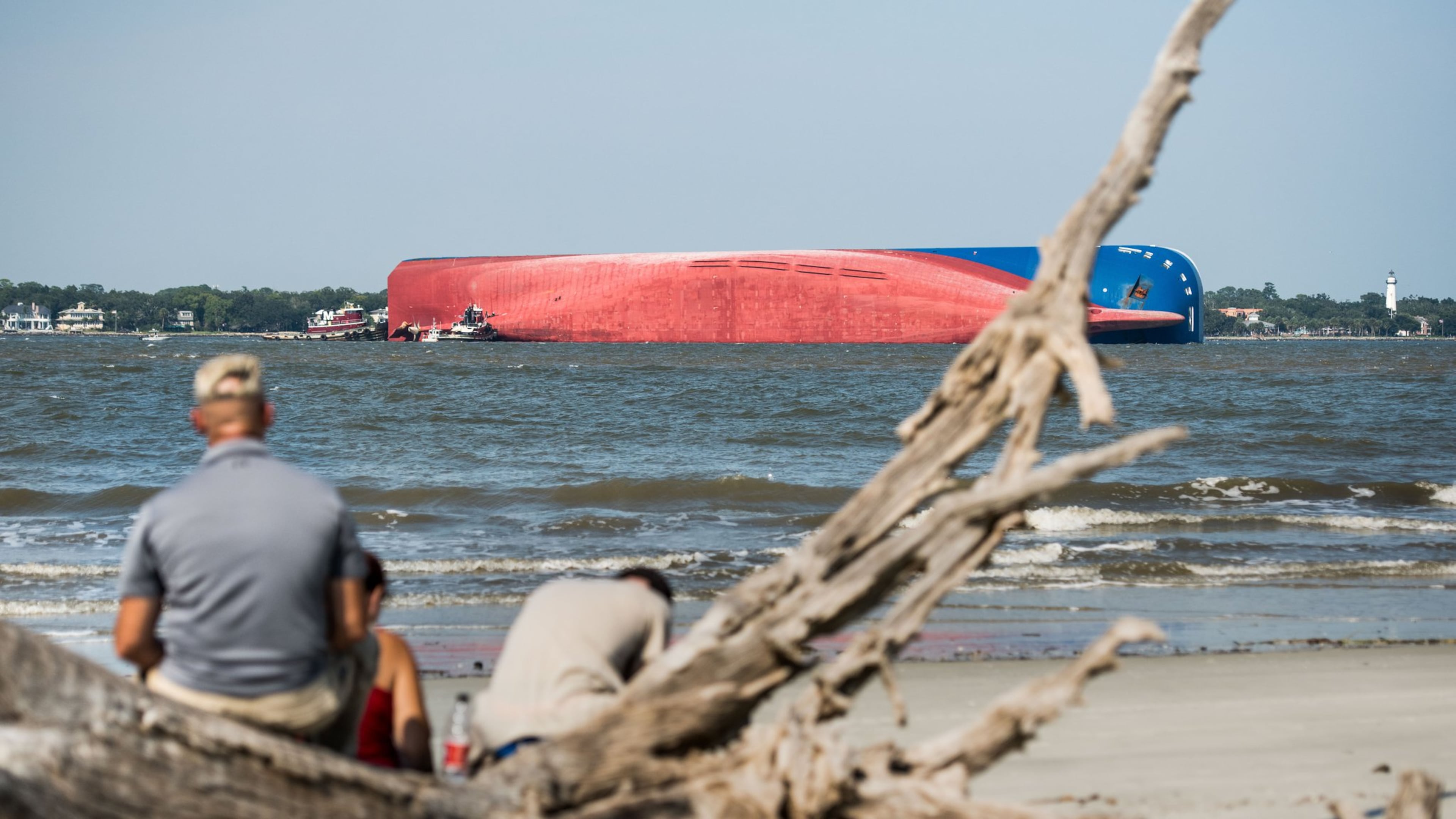People watch from Jekyll Island as emergency responders work to rescue crew members from a capsized cargo ship on September 9, 2019 in St Simons Island, Georgia. A 656-foot vehicle carrier, the M/V Golden Ray departed the Brunswick port and suffered a fire on board, capsizing in St. Simons Sound. (Photo by Sean Rayford/Getty Images)