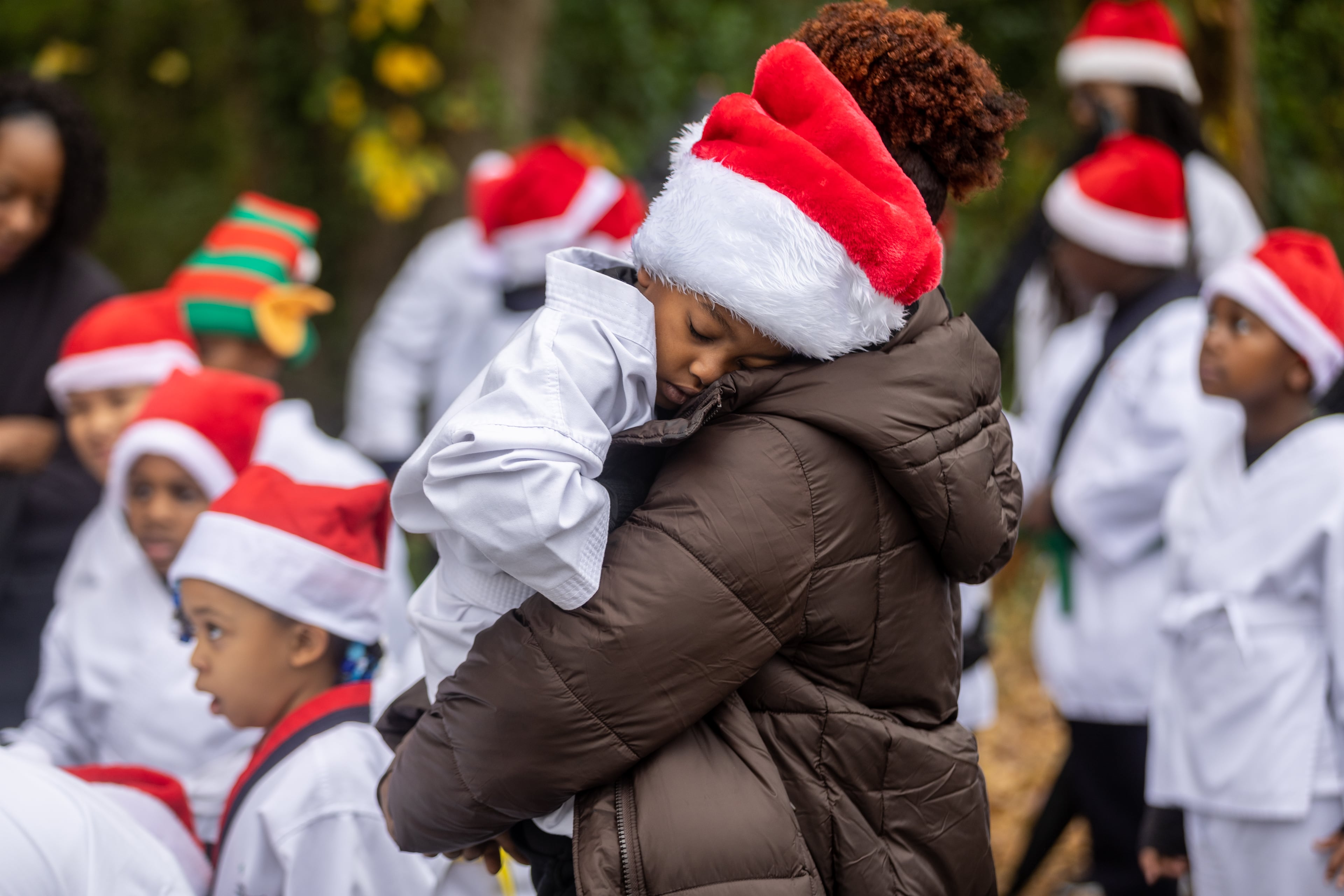 Brittany Love holds Jonah Smith, 4, as they line up before the start of the College Park Christmas Parade on Saturday, Dec. 3, 2022. (Photo: Steve Schaefer / steve.schaefer@ajc.com)
