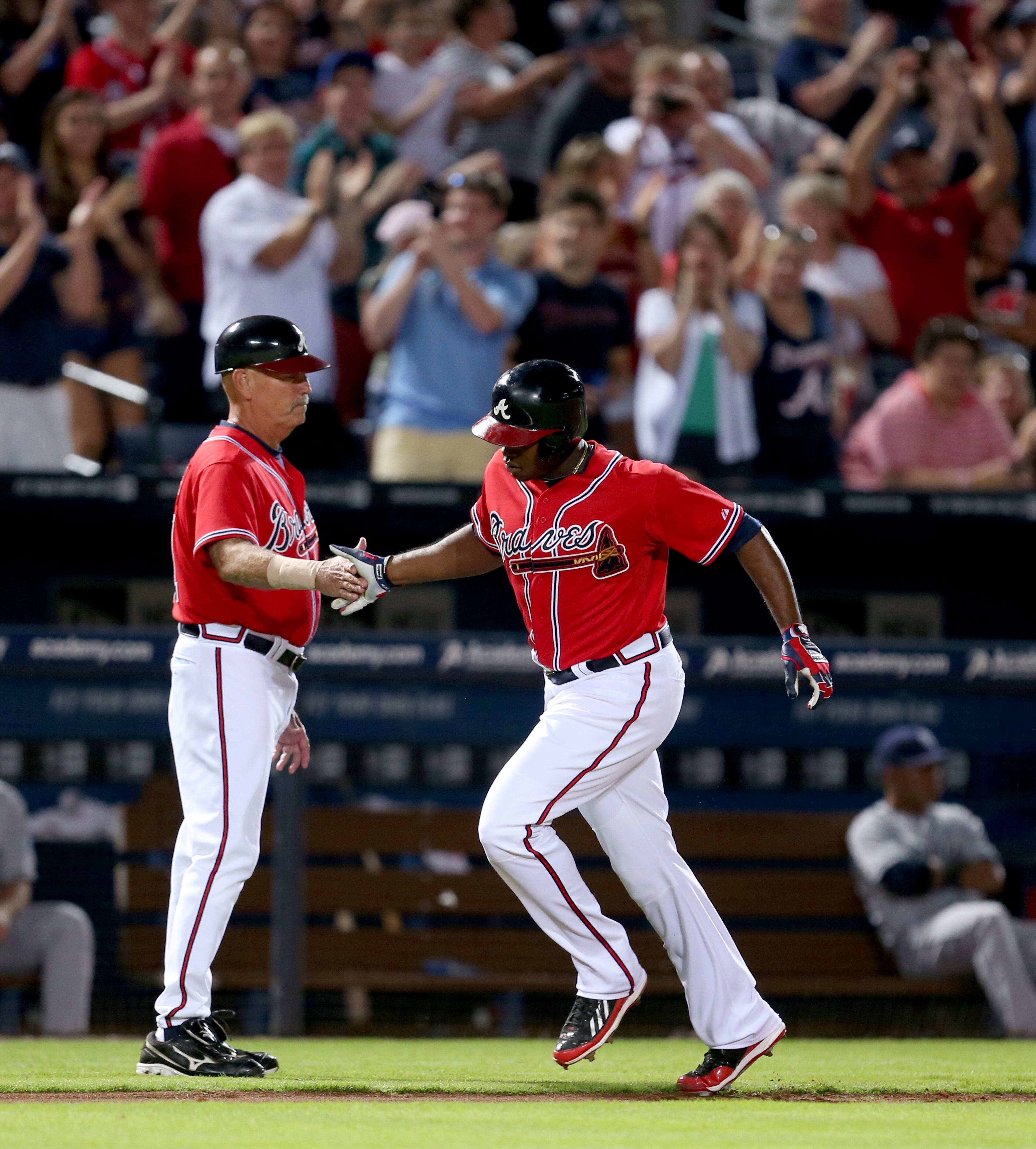 Braves outfielder Justin Upton (8) celebrates with Atlanta Braves third base coach Brian Snitker after Upton's solo home run in the 4th inning of their game against the San Diego Padres at Turner Field Friday night in Atlanta, Ga., September 13, 2013. The Braves scored three runs in the 4th inning. JASON GETZ / JGETZ@AJC.COM