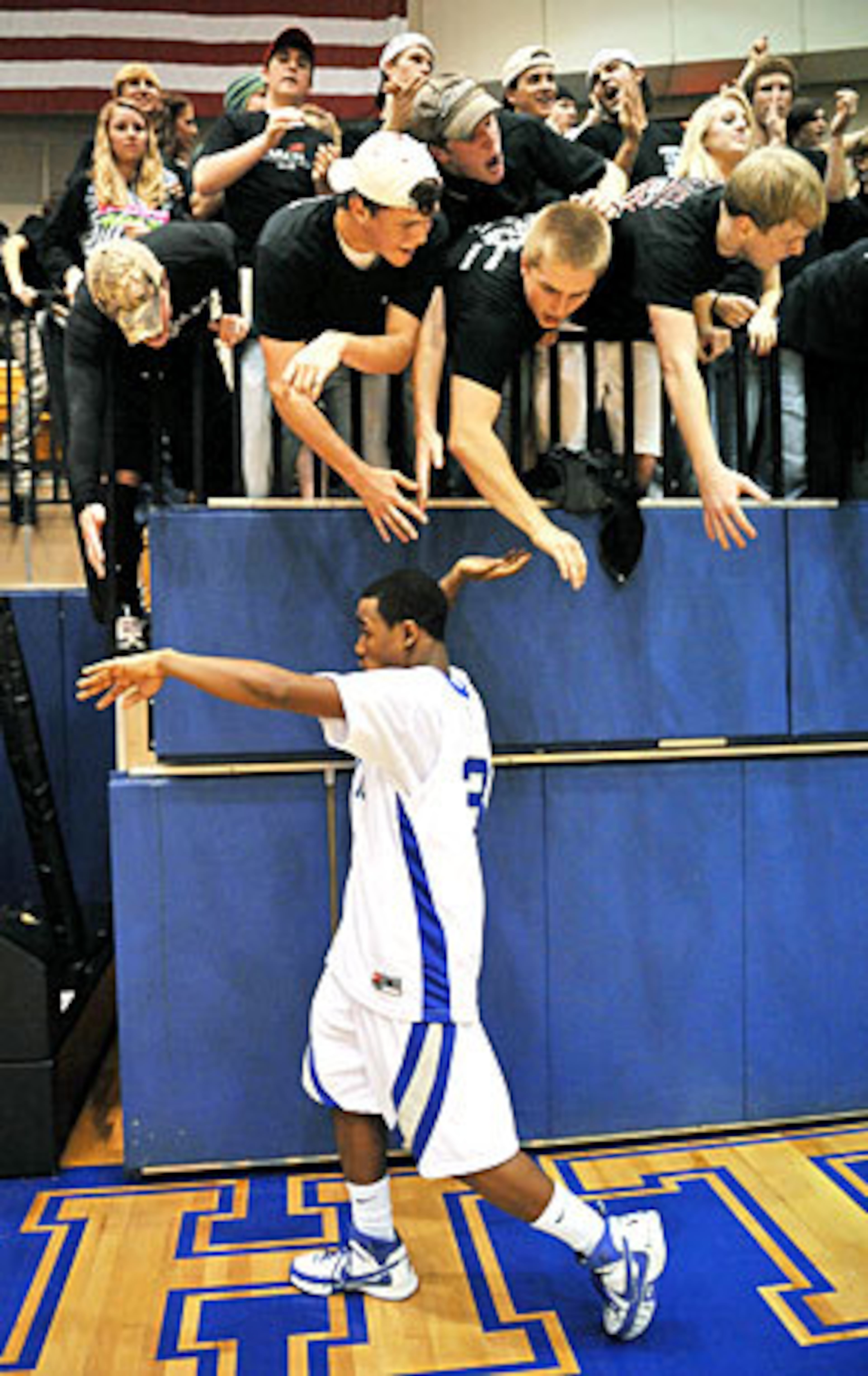 Give me five! Centennial fans celebrate with Delonte Doles after the Knights' victory over Meadowcreek.