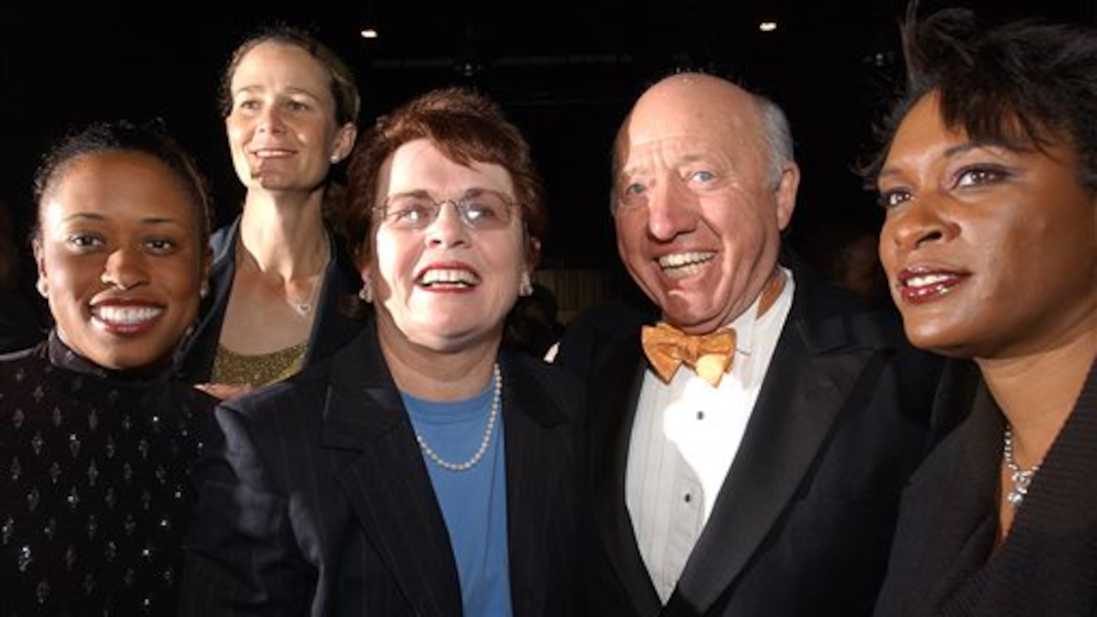 FILE - In this Nov. 23, 2002, file photo, tennis commentator Bud Collins, second from right, poses with tennis players, from left, Chanda Rubin, Pam Shriver, Billie Jean King and Zina Garrison at a reception in Boston. Collins, the tennis historian and American voice of the sport in print and on TV for decades, died Friday, March 4, 2016 at home in Brookline, Mass., his wife, Anita Ruthling Klaussen said. He was 86 (AP Photo/Michael Dwyer, File)