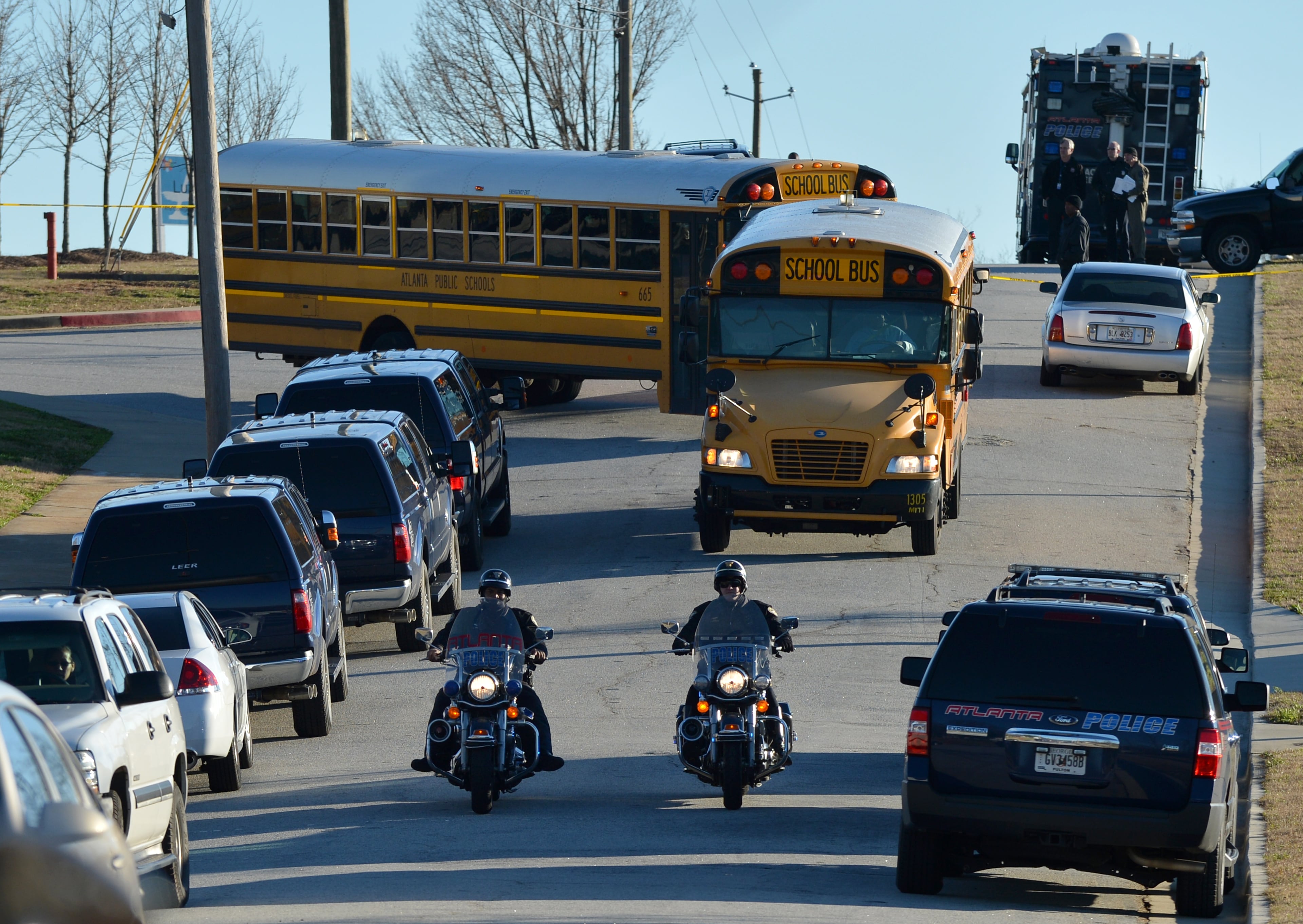 Police escort Price Middle School buses to a drop-off point at a local church just down the street from the school.