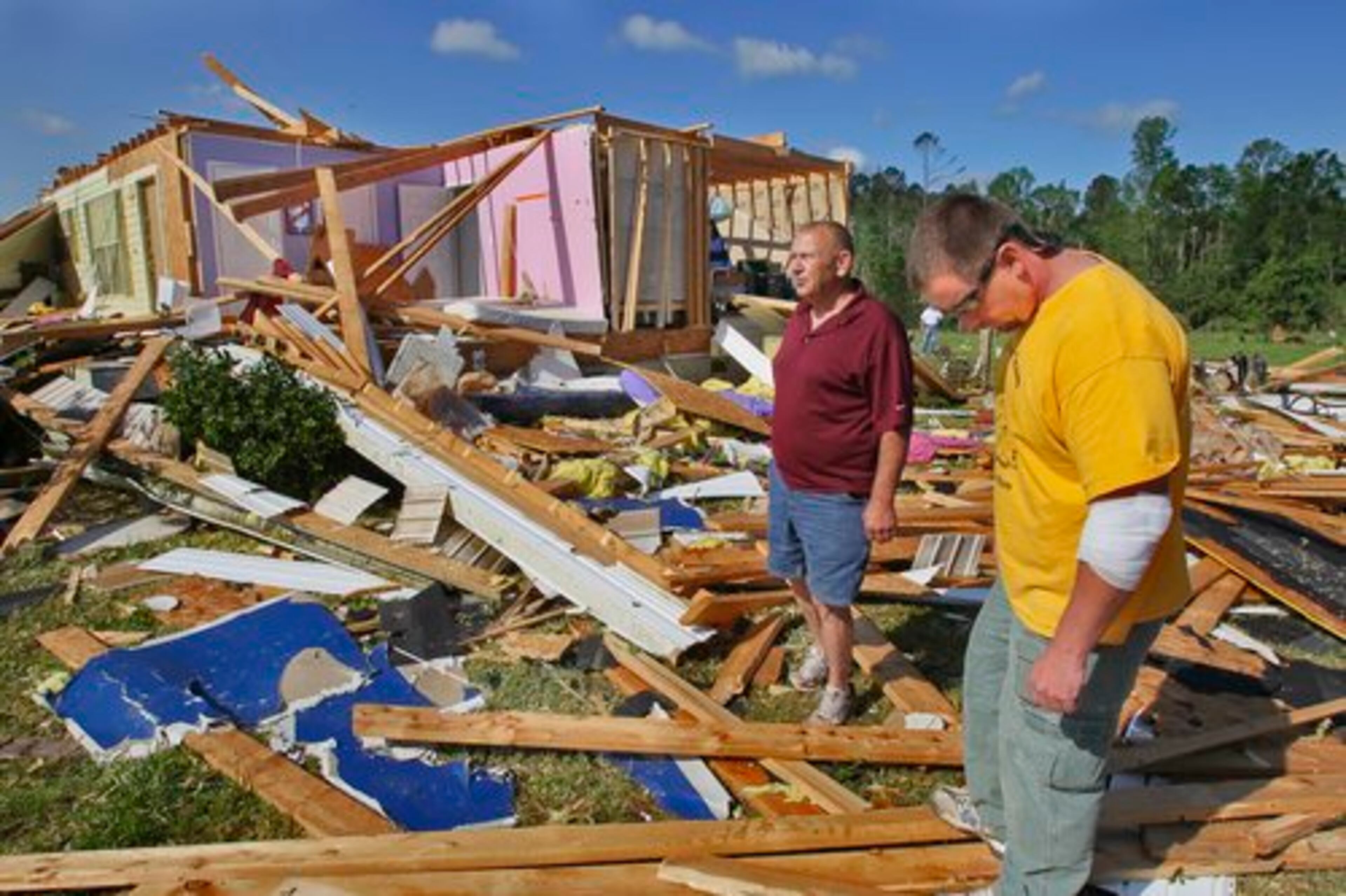 Sgt. Joe Peavy (right) shows retired Spalding County Sheriff Sgt. Charlie Manor where Peavy's daughter Kylie was hurled from the house by a tornado.
