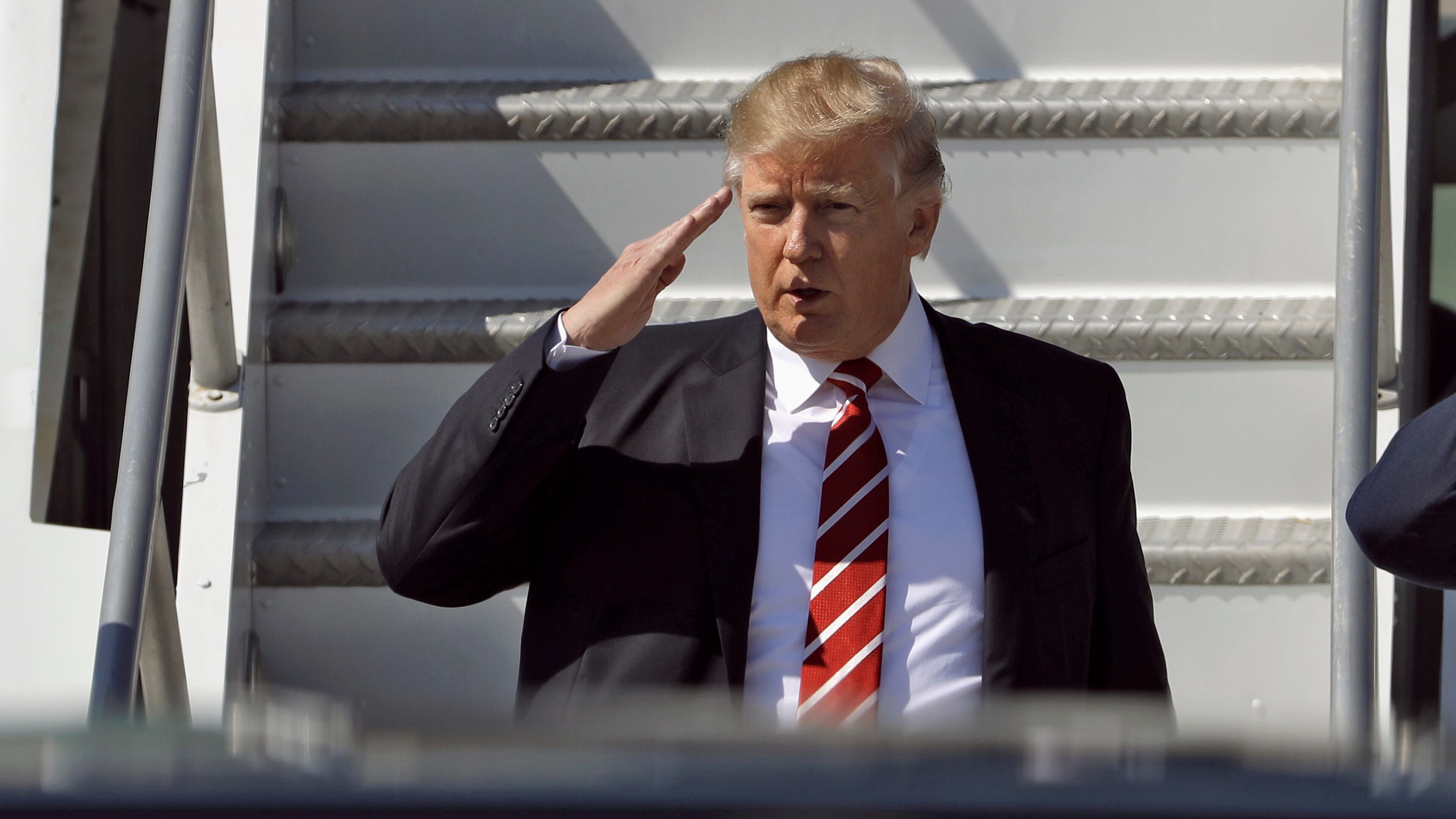 FILE - In this Monday, Feb. 6, 2017, file photo, U.S. President Donald Trump salutes as he arrives on Air Force One at MacDill Air Force Base, in Tampa, Fla. New Zealand's Prime Minister Bill English said Tuesday he told Trump during a phone call that he disagreed with his travel and refugee ban but that the conversation remained amicable. (AP Photo/Chris O'Meara/File)