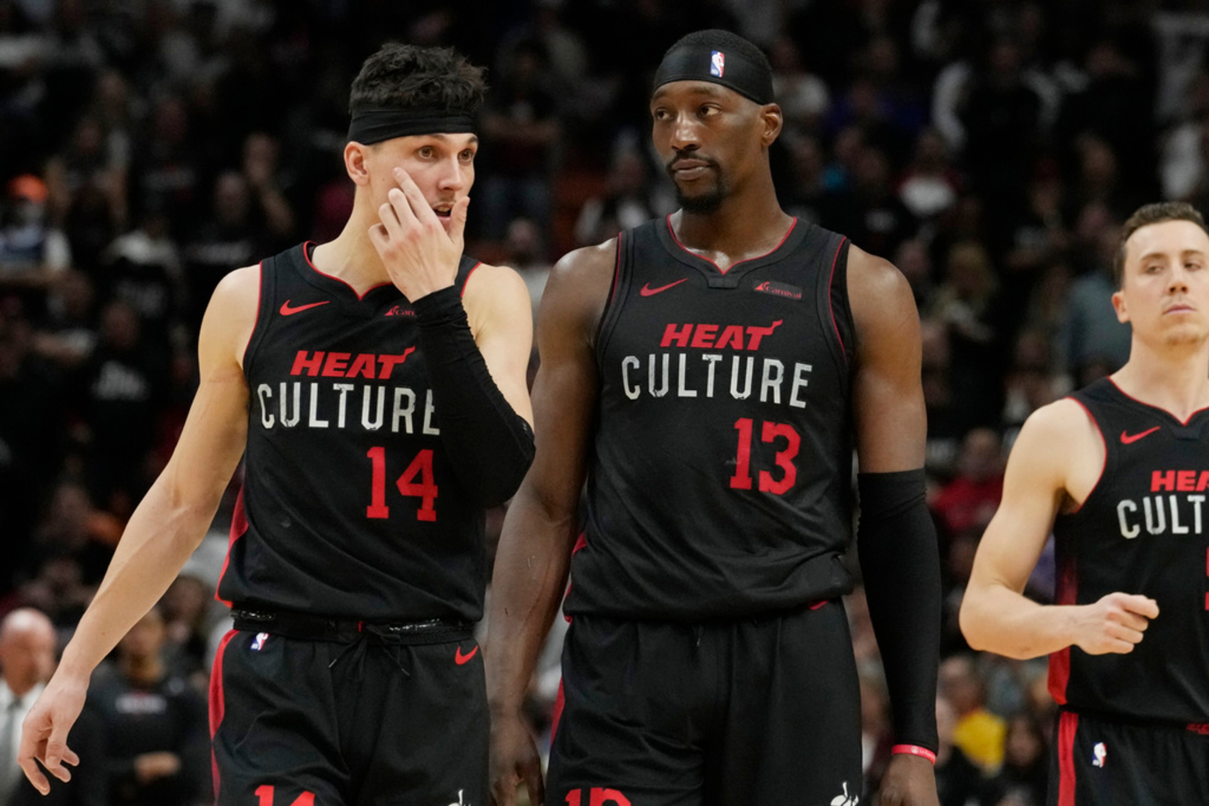 Miami Heat guard Tyler Herro (14) and center Bam Adebayo (13) talk on the court during the second half of an NBA basketball game, Friday, Jan. 19, 2024, in Miami. The Hawks defeated the Heat 109-108. (AP Photo/Marta Lavandier)