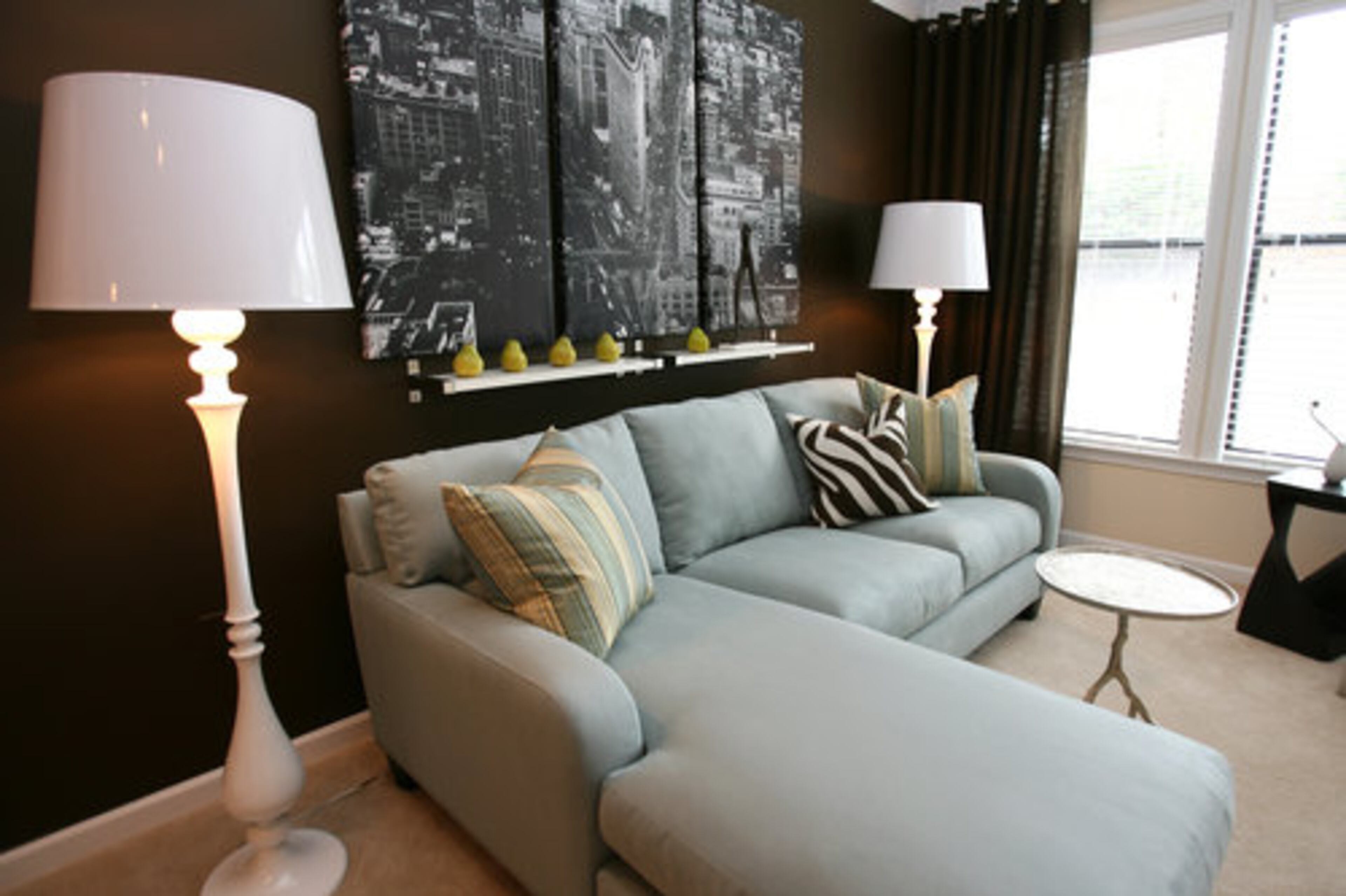 "She's a career-minded young woman on the go, and this is her sanctuary. She wants a comfortable space, very soothing and very adult," Grayson said. That's why he chose a relaxed chocolate and blue color scheme. Grayson got creative with the living room art. "I bought a photo mural at Ikea and split it into three panels, which makes it look totally different."