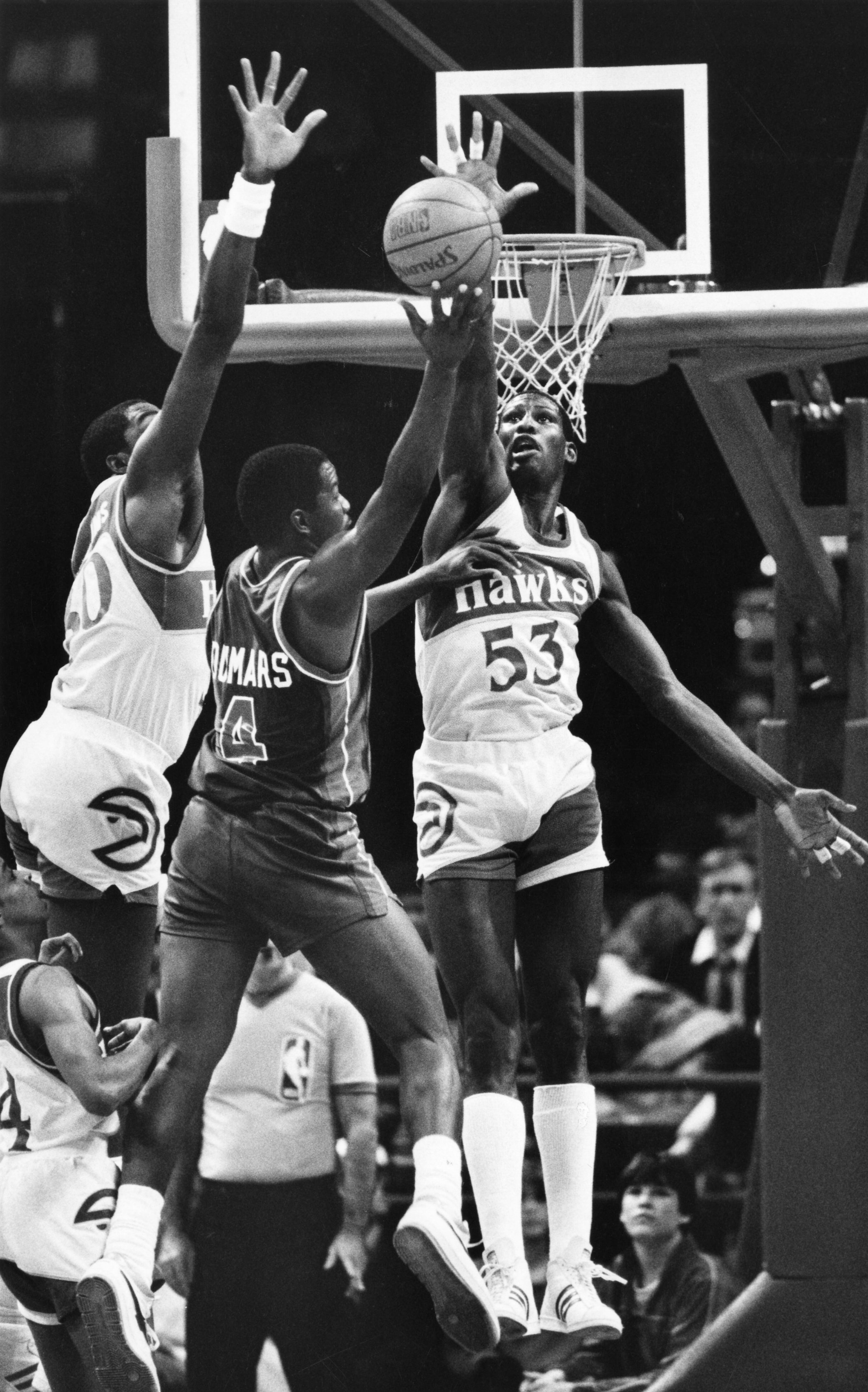 Cliff Levingston of the Hawks challenges the shot of Detroit's Joe Dumars in 1986. AJC file photo