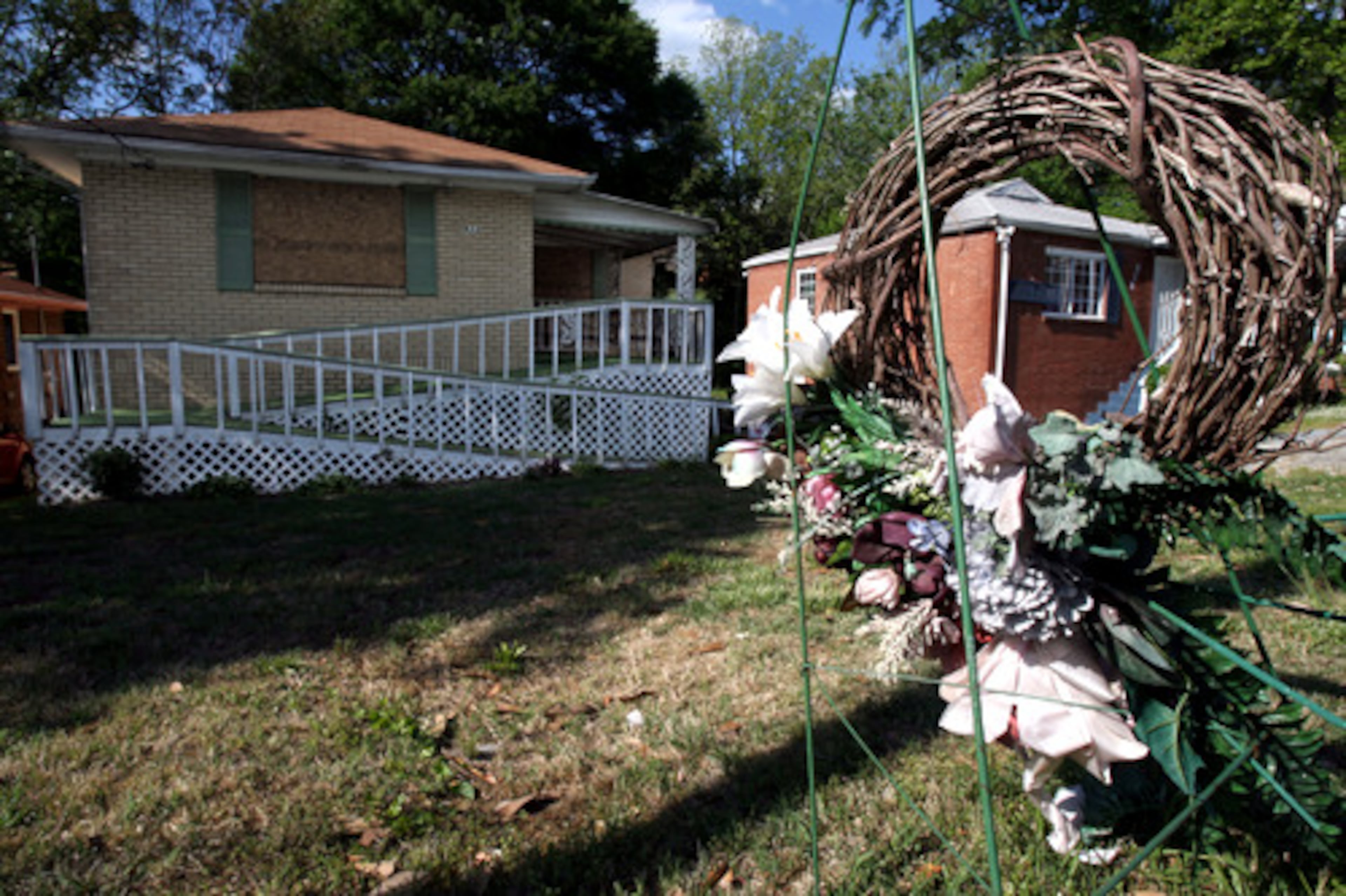 Flowers remain in front of Johnston's home a day after two Atlanta officers pleaded guilty in the dishonestly arranged drug raid that left the elderly woman dead last year.