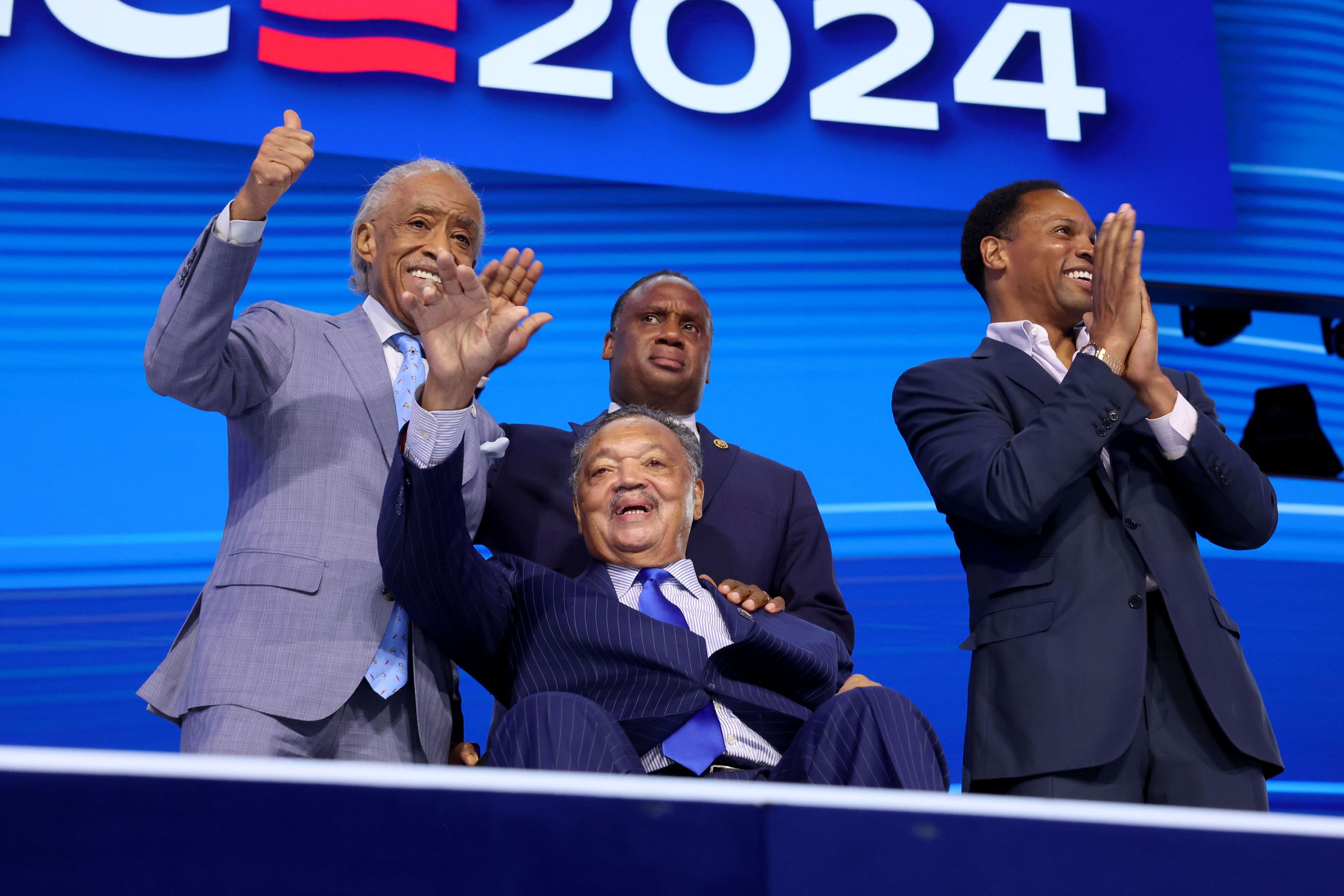 The Rev. Jesse Jackson (front center) waves as he appears on stage during the 2024 Democratic National Convention at United Center in Chicago on Monday, Aug. 19, 2024, in Chicago. (Robert Gauthier/Los Angeles Times/TNS)