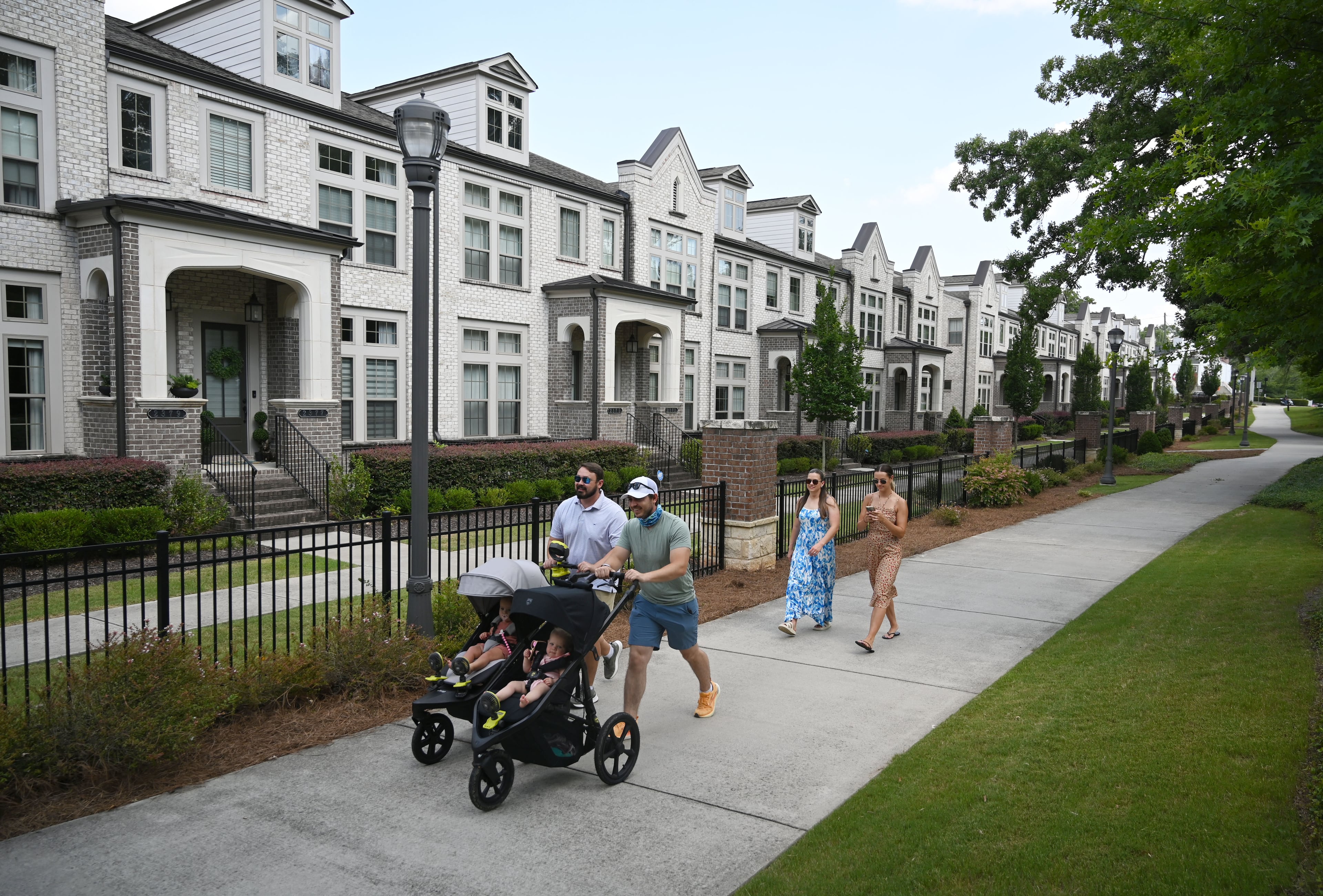 Residents stroll down a sidewalk in Brookhaven on Friday, June 26, 2026. (Hyosub Shin/AJC)