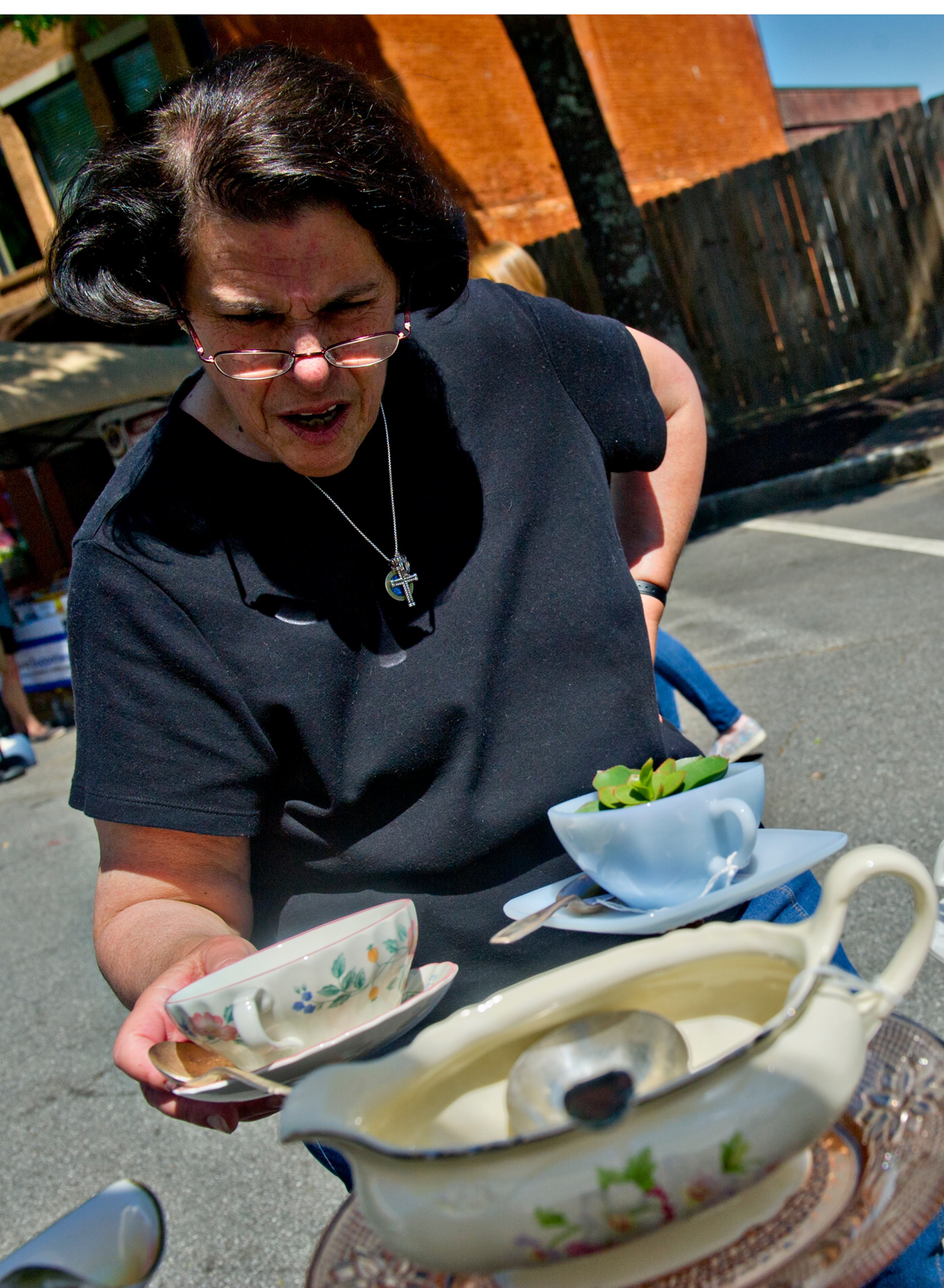 Carol Palermo looks at the artwork for sale in Tobi Stoll and Sheila Cooley's booth during the May-retta Daze Arts & Craft Festival at Glover Park in Marietta on Sunday, May 4, 2014.