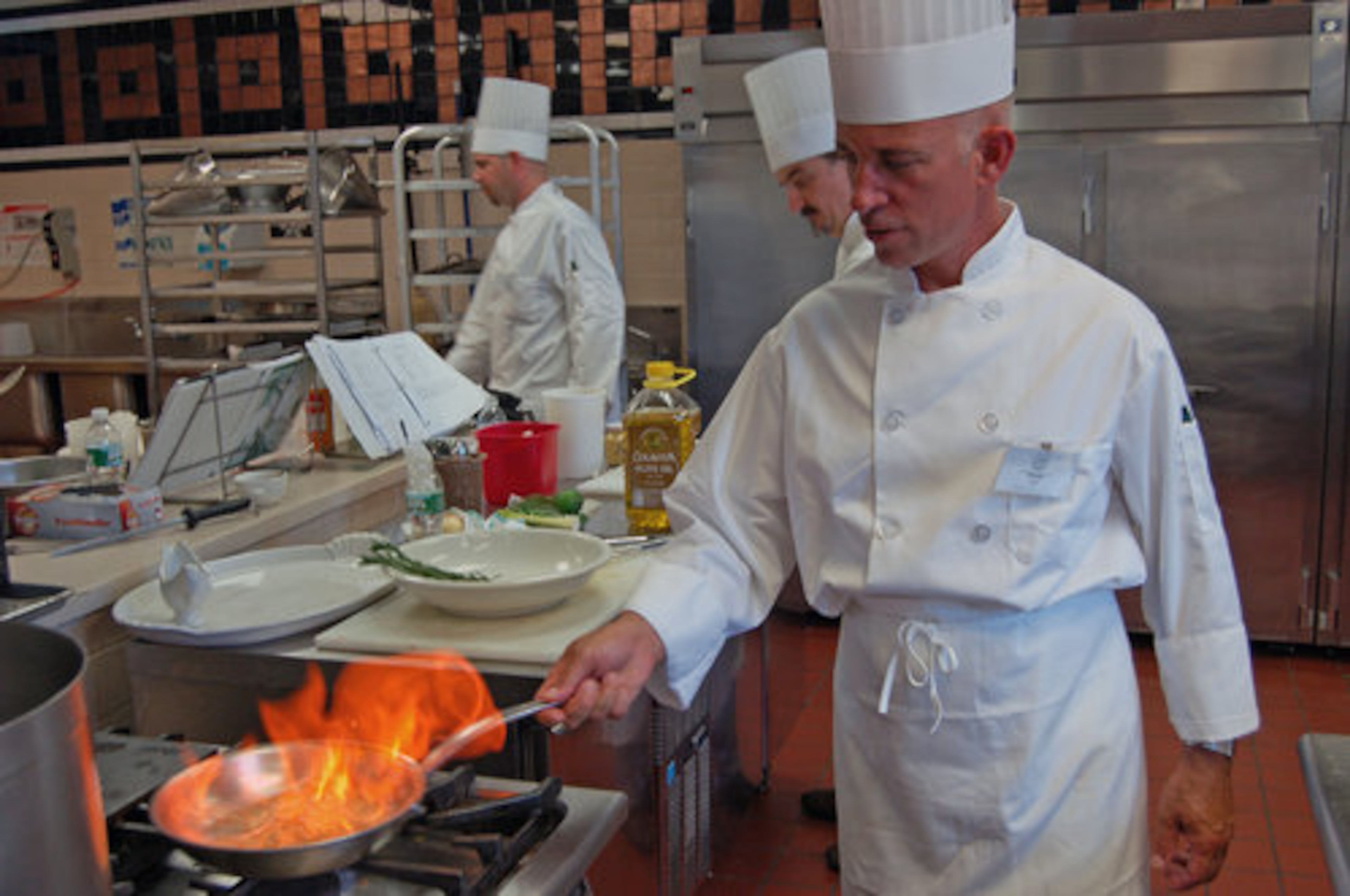 Boot campers work on their techniques and prepare dishes to present to the instructor for evaluation. At lunch, they eat what they've cooked.