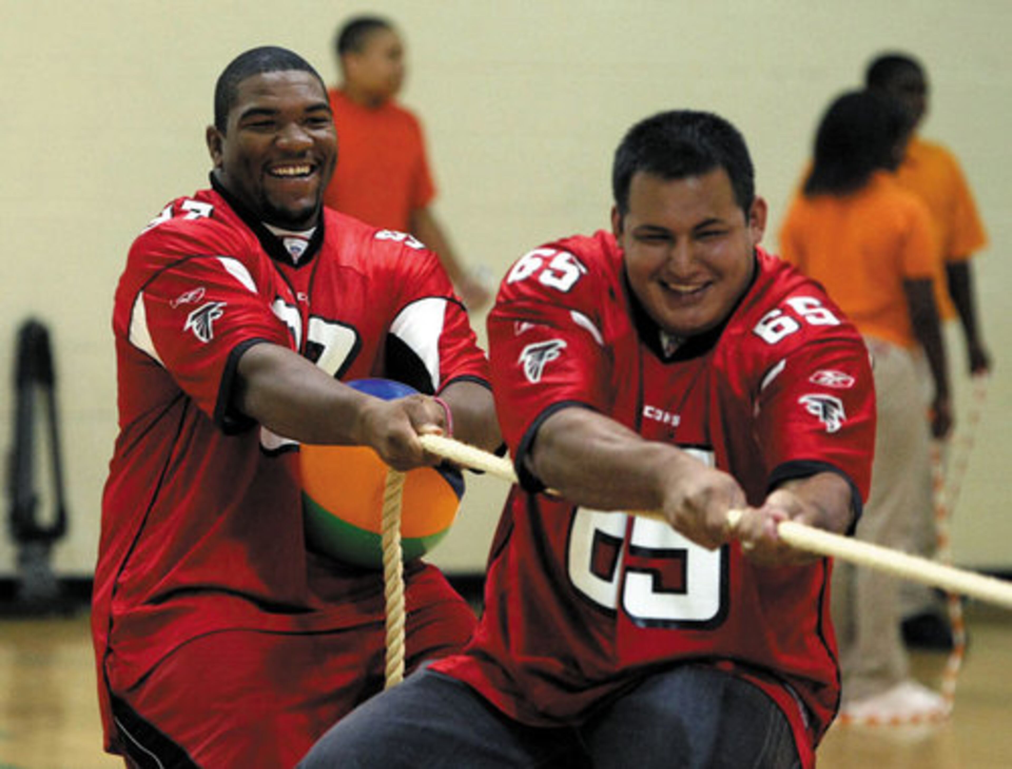 Defensive tackle Trey Lewis (left) and guard Jose Valdez participate in tug-o-war with a group of students.