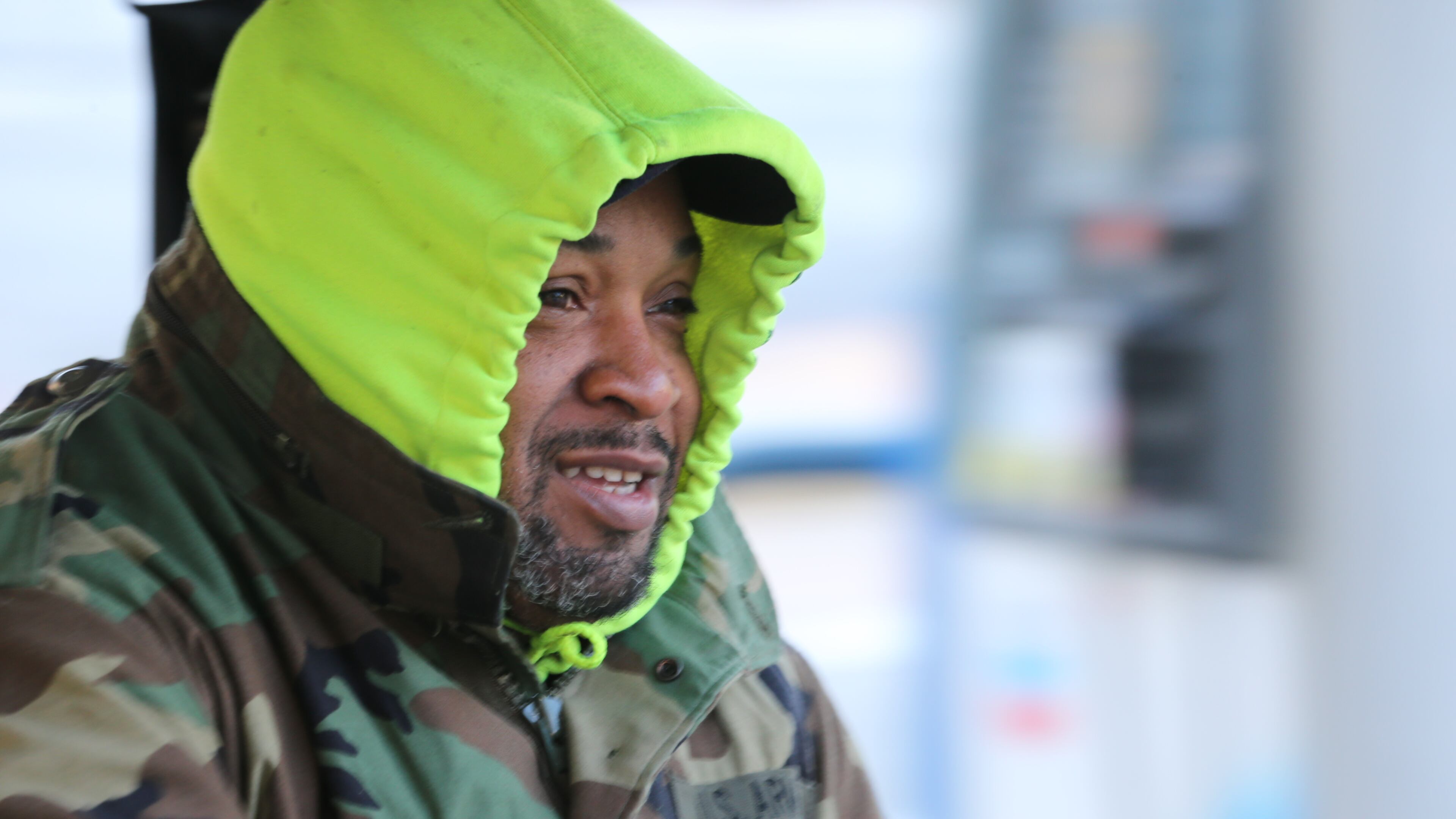 T. Nelson with the Midtown Alliance tries to keep warm on Wednesday morning as temperatures plummeted near the freezing point.