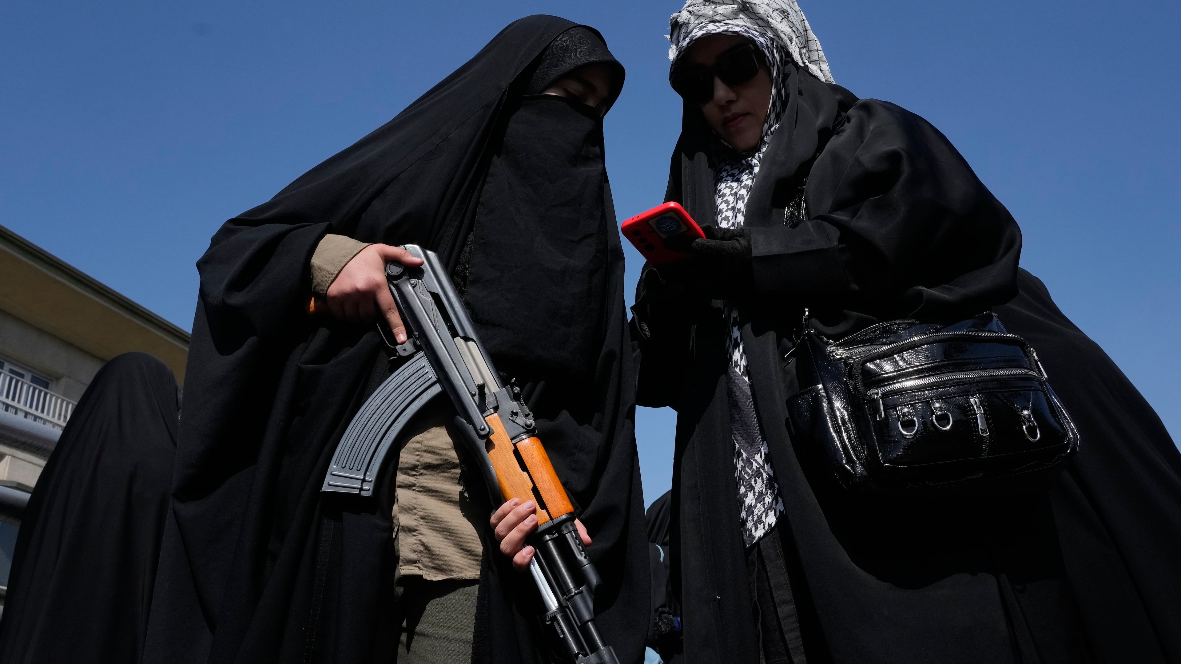 A woman member of the Basij paramilitary, affiliated with Iran's Revolutionary Guard, holds her gun during a state-organized rally in support of the supreme leader marking National Girl's Day in Tehran, Iran, Friday, April 17, 2026. (AP Photo/Vahid Salemi)