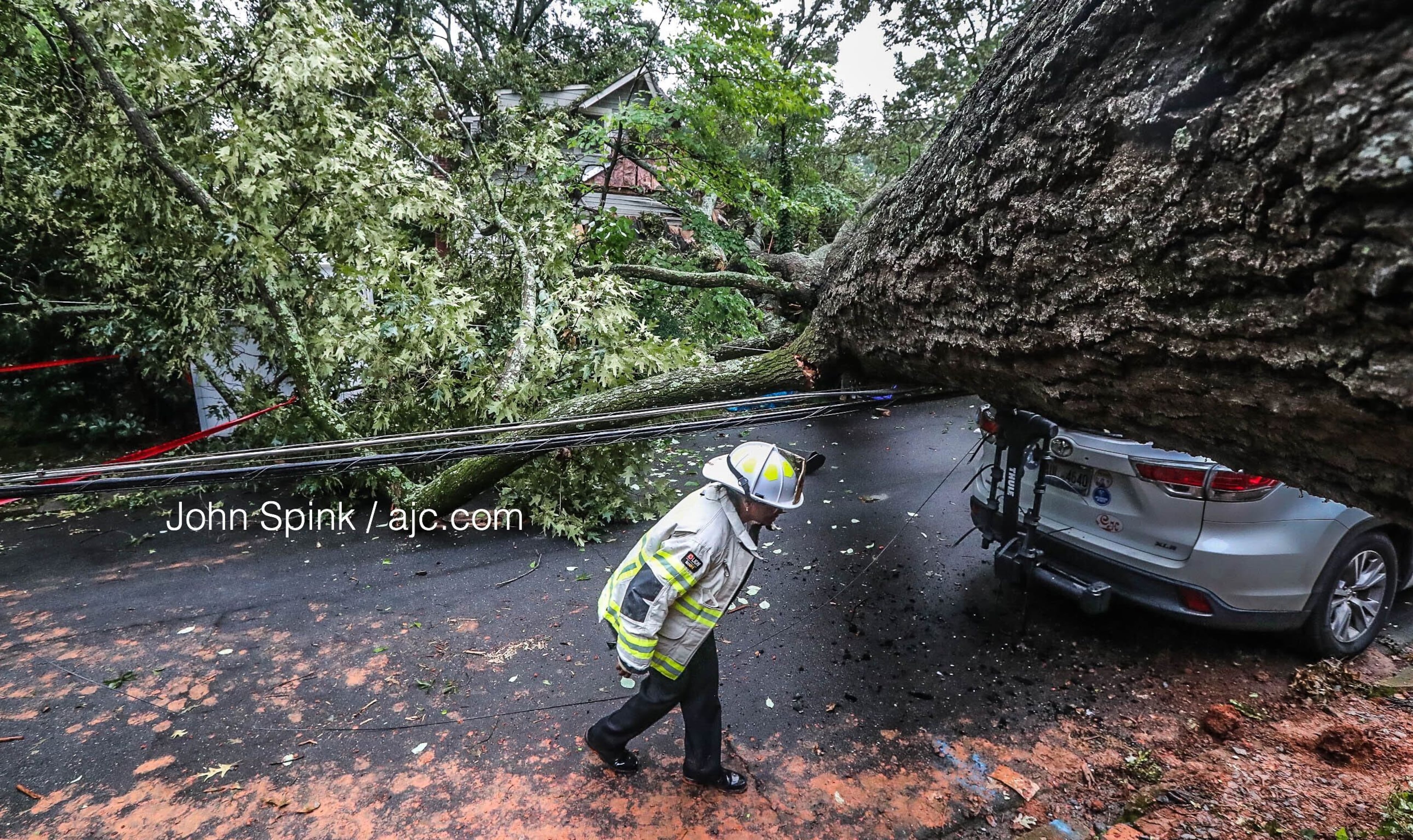 Deputy Chief Vera Morrison walks along Drexel Avenue in Decatur, where a tree landed on two homes.