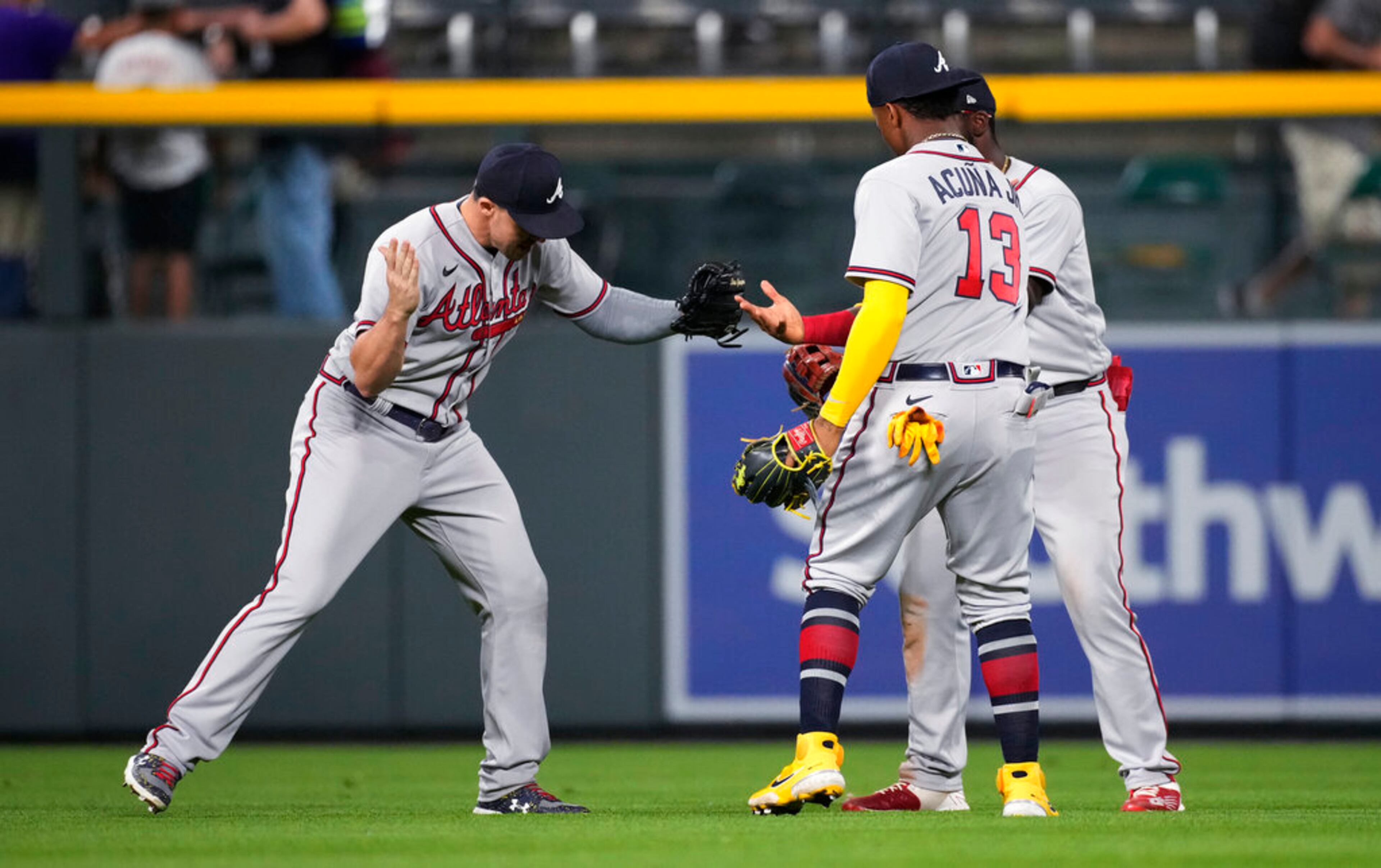 Atlanta Braves left fielder Adam Duvall, left, celebrates with right fielder Ronald Acuna Jr., front right, and center fielder Michael Harris II after the team's baseball game against the Colorado Rockies on Saturday, June 4, 2022, in Denver. (AP Photo/David Zalubowski)