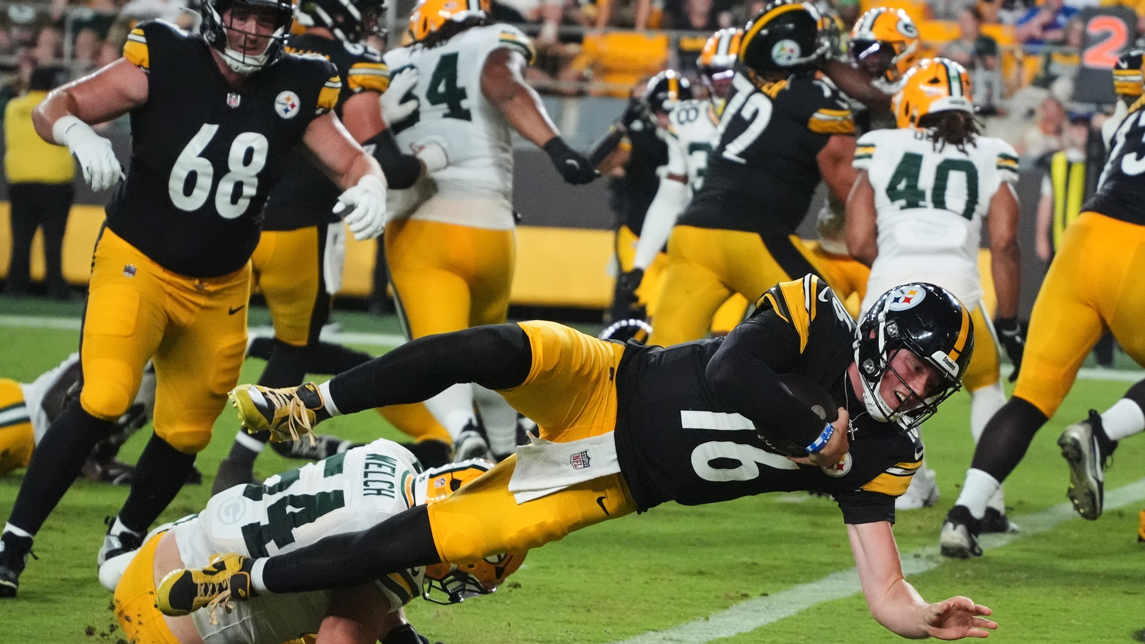 Pittsburgh Steelers quarterback Drew Allar (16) divers over Green Bay Packers linebacker Kristian Welch into the end zone for a touchdown in the second half of a preseason NFL football game in Pittsburgh, Thursday, Aug. 13, 2026. (AP Photo/Gene J. Puskar)