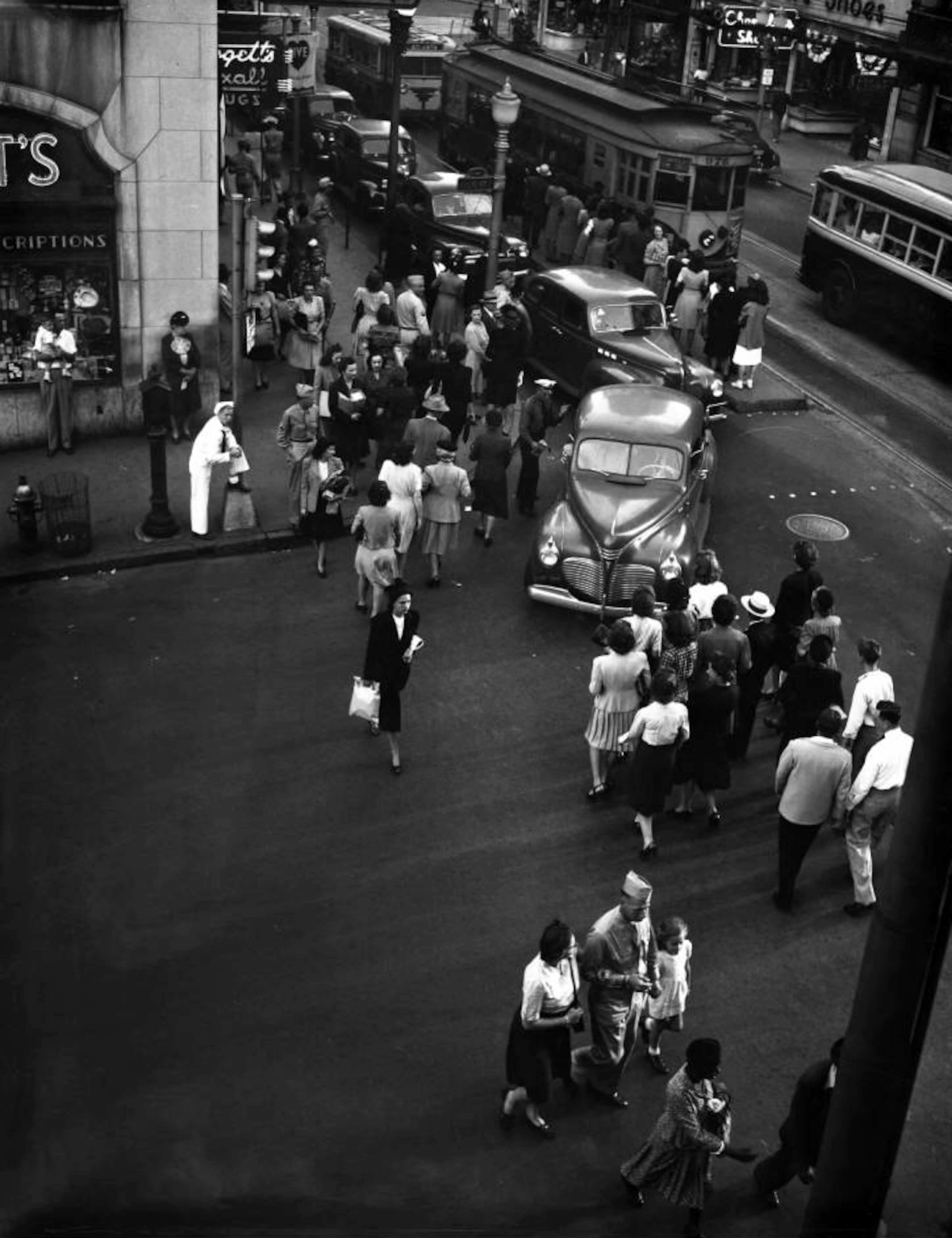 Pedestrians crossing the street at a busy intersection, which appears to be Ellis at Peachtree Street. September 1945.