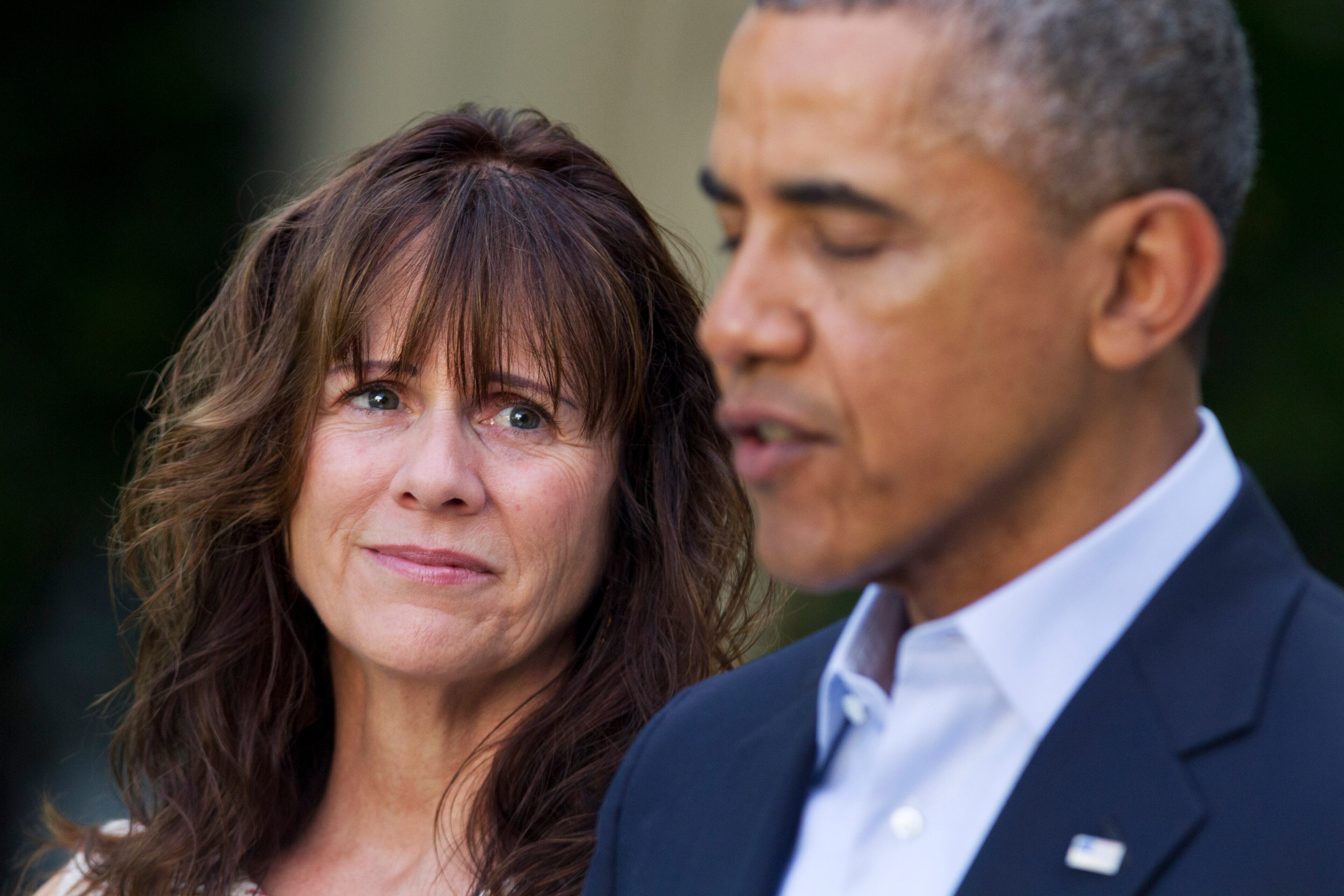 Jani Bergdahl, mother of U.S. Army Sgt. Bowe Bergdahl, watches as President Barack Obama speaks about the release of her son, during a news conference in the Rose Garden of the White House in Washington on Saturday, May 31, 2014. Bergdahl, 28, had been held prisoner by the Taliban since June 30, 2009. He was handed over to U.S. special forces by the Taliban in exchange for the release of five Afghan detainees held by the United States. (AP Photo/Jacquelyn Martin)