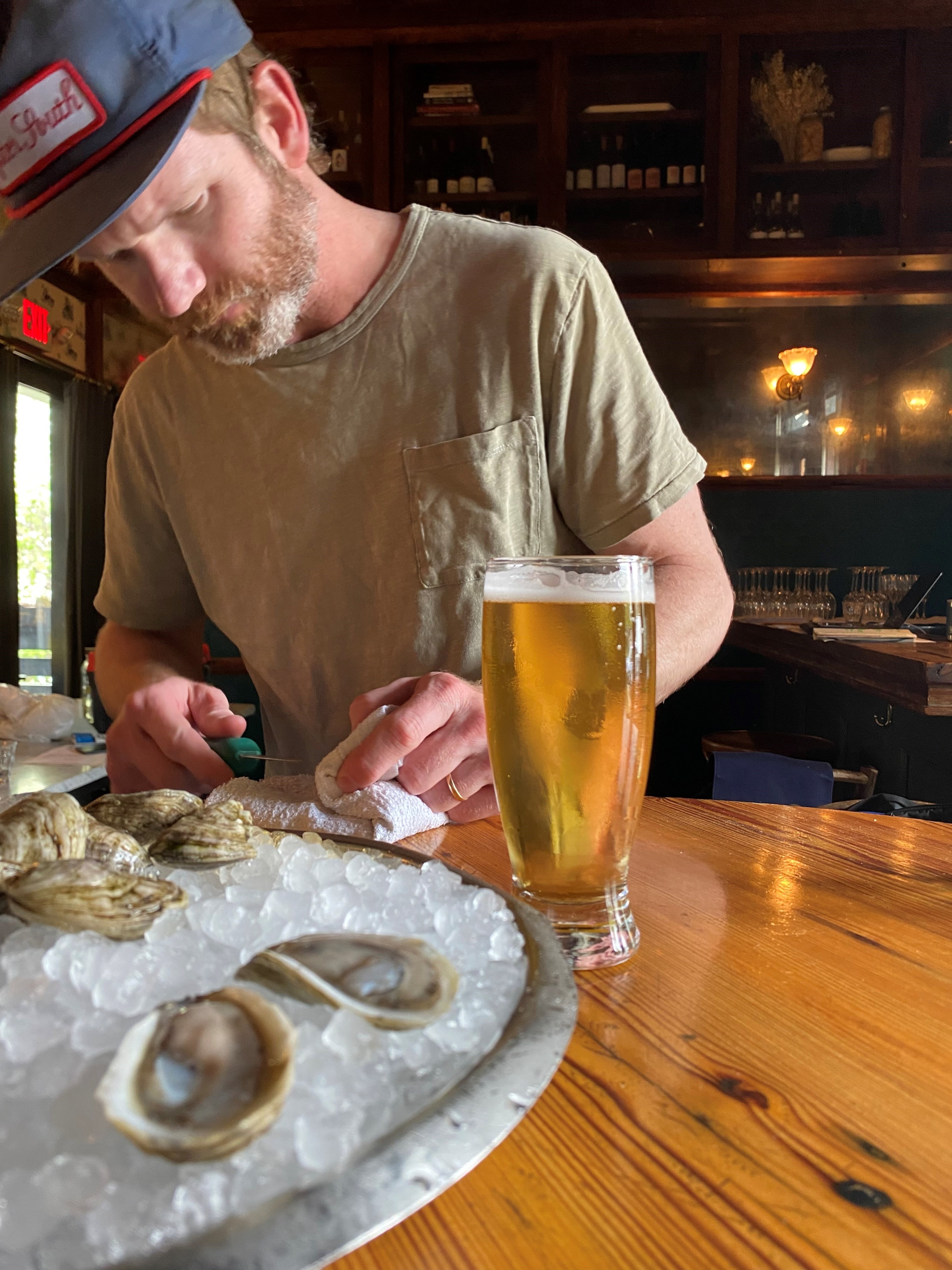 Bryan Rackley shucks Shiny Dimes oysters. Kimball House is known for its oysters, with 18 varieties from both coasts and the Gulf. (File/AJC)