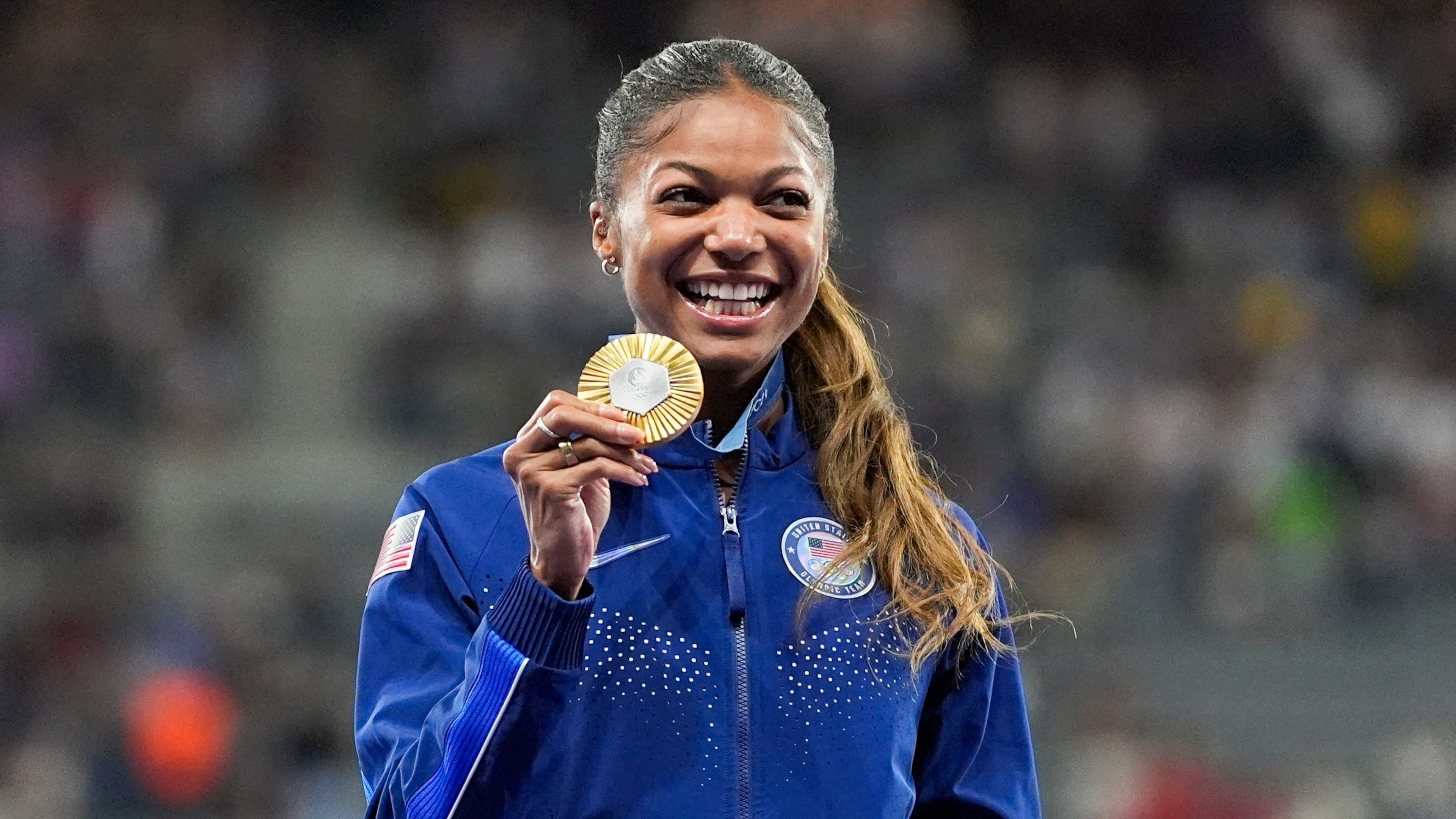 FILE - Gold medalist Gabby Thomas stands on the podium after the women's 200-meter at the 2024 Summer Olympics, Wednesday, Aug. 7, 2024, in Saint-Denis, France. (AP Photo/Matthias Schrade, File)