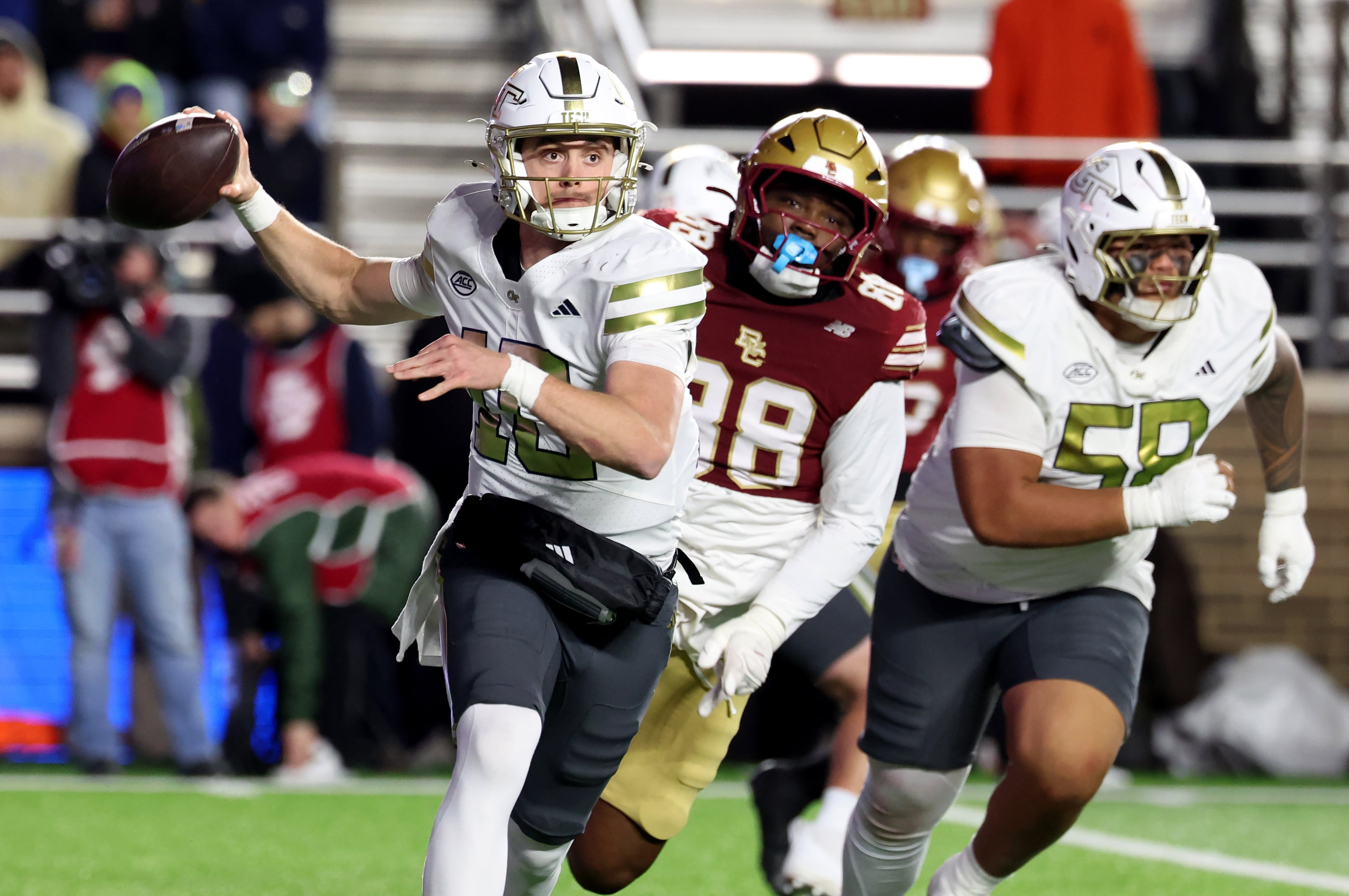 Georgia Tech quarterback Haynes King, left, is chased by Boston College defensive lineman Sedarius McConnell (88) during the second half of an NCAA college football game Saturday, Nov. 15, 2025, in Boston. (AP Photo/Mark Stockwell)
