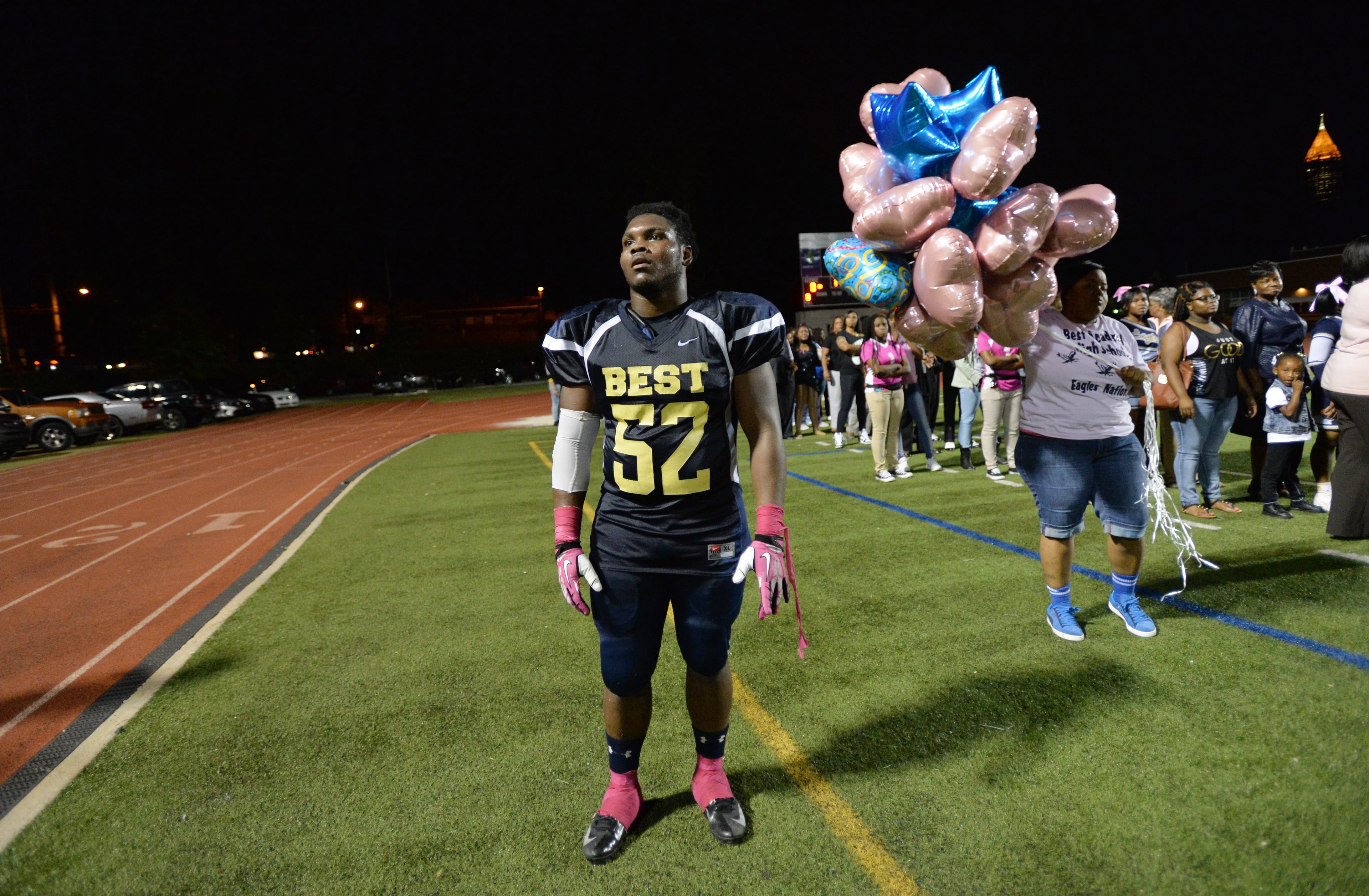 Darius Marshall, 18, looks to the football stand to check if his sister Ashley Roberson has arrived for his senior night event. HYOSUB SHIN / HSHIN@AJC.COM