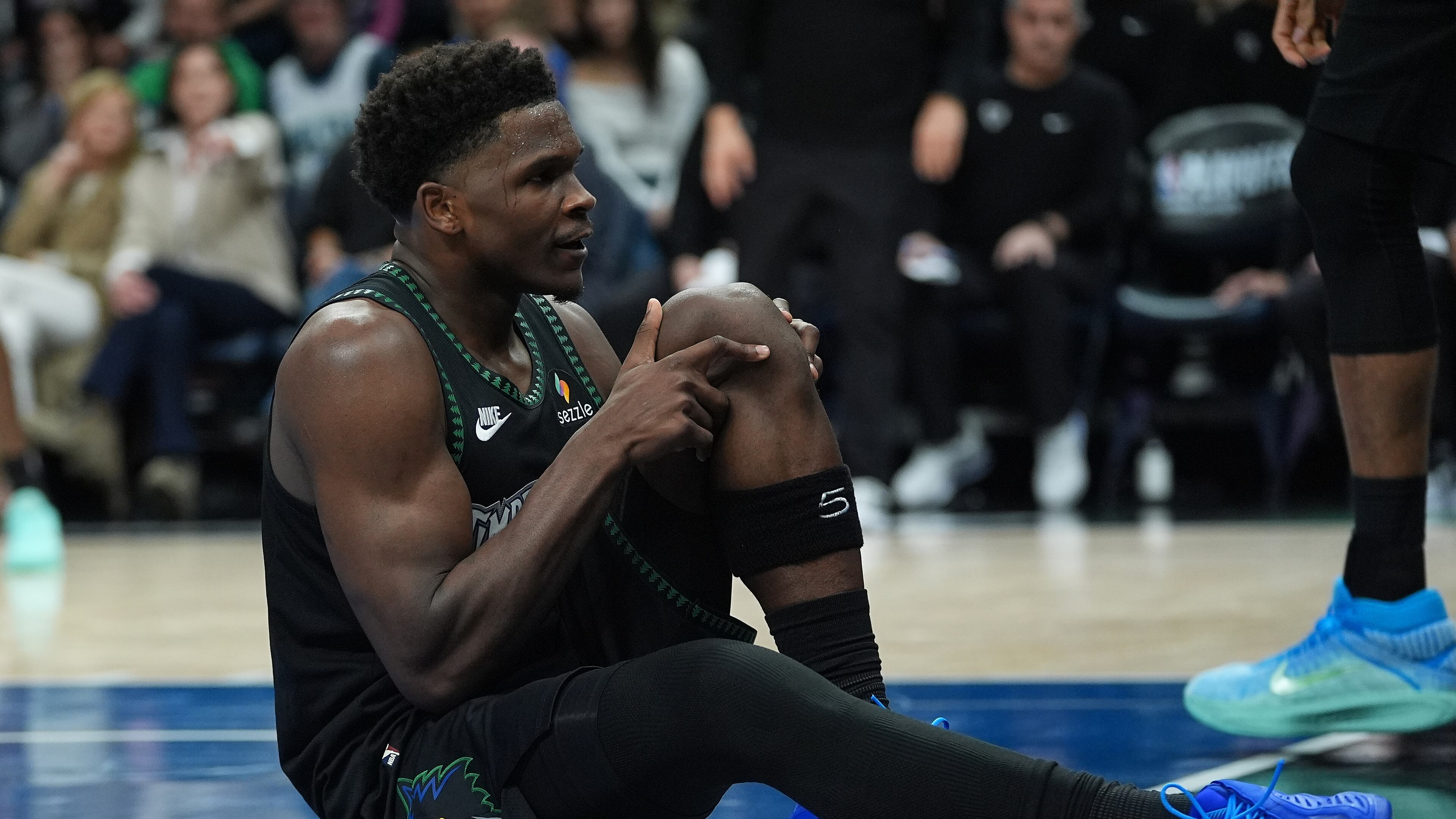 Minnesota Timberwolves guard Anthony Edwards grabs his knee after an injury during the first half of Game 4 of a first-round NBA basketball playoff series against the Denver Nuggets, Saturday, April 25, 2026, in Minneapolis. (AP Photo/Abbie Parr)