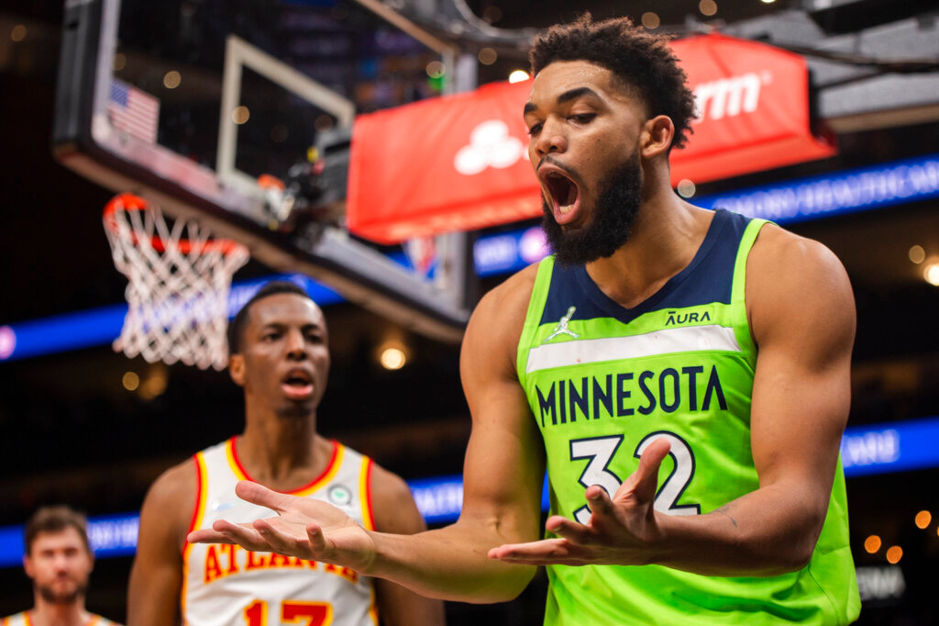 Minnesota Timberwolves center Karl-Anthony Towns (32) reacts to foul by Atlanta Hawks forward Onyeka Okongwu (17) during the second half of an NBA basketball game Wednesday, Jan. 19, 2022, in Atlanta. (AP Photo/Hakim Wright Sr.)