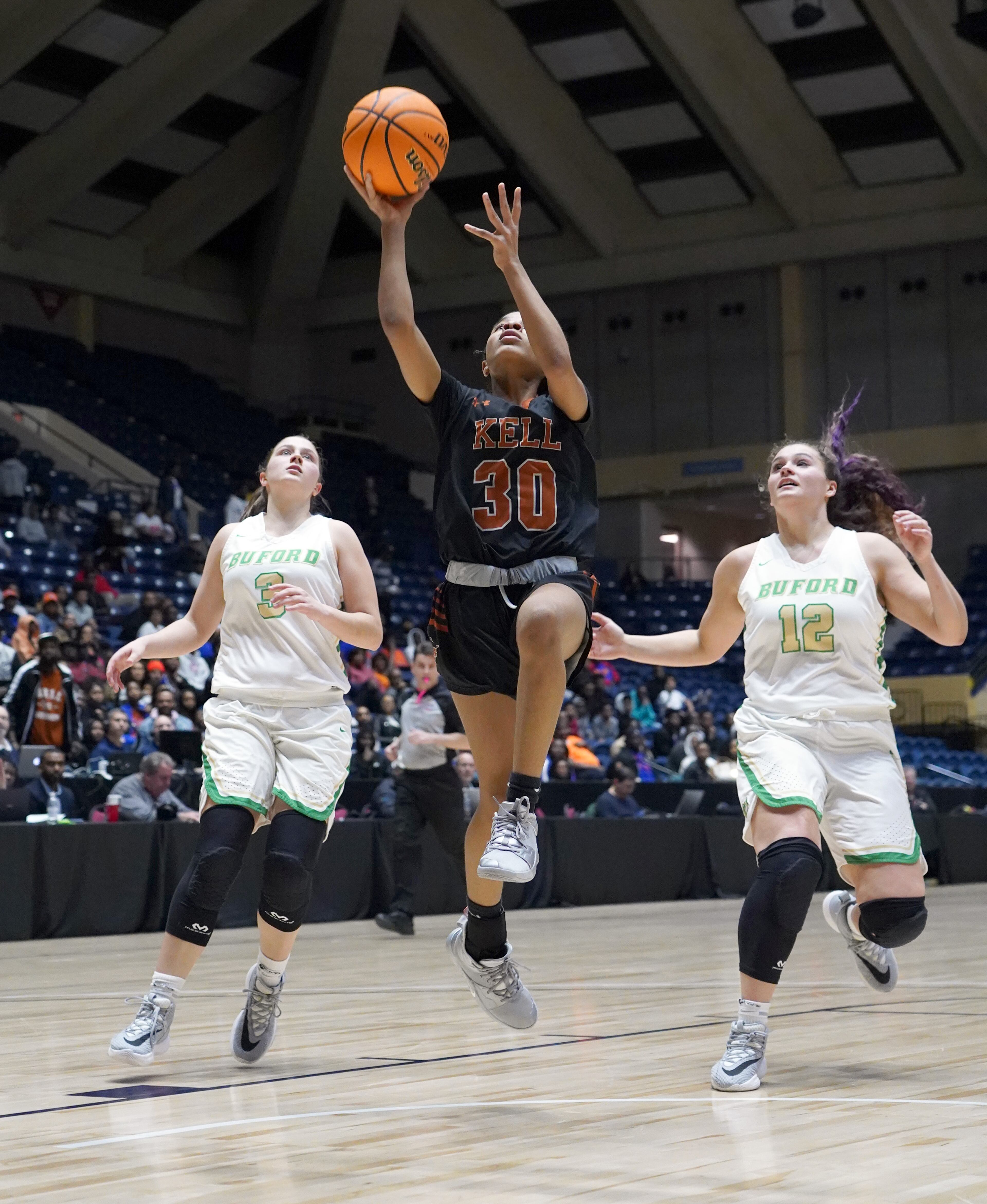 Kell's Cyrstal Henderson (30) drives between Buford's Tate Walters (3) and Kaitlyn Klein (12) in the second half at the Class AAAA girls title basketball game at the Macon Centreplex, Friday March 6, 2020, in Macon. Tami Chappell for the Atlanta Journal Constitution