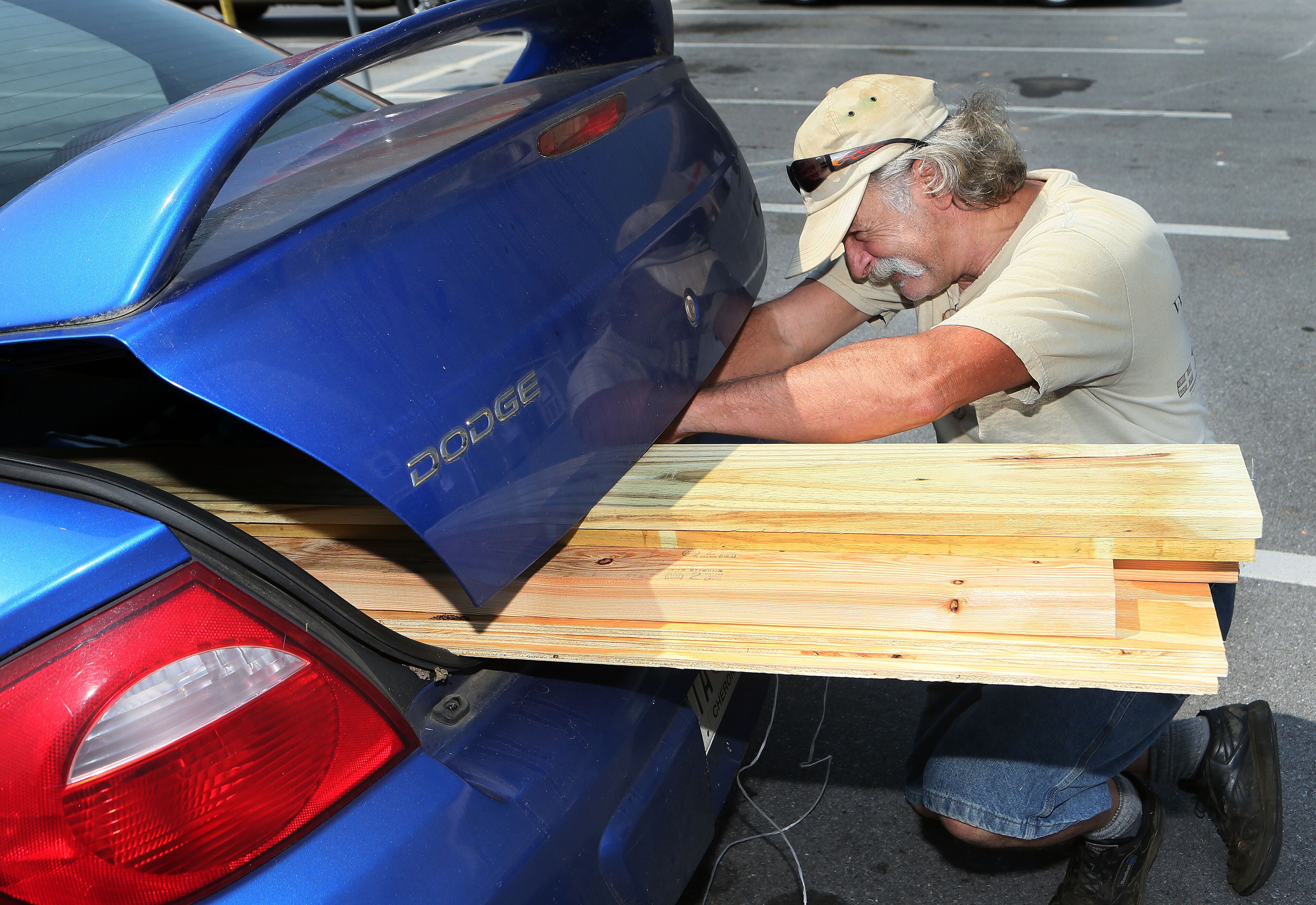 McWilliams ties down lumber to transport it from the Home Depot store in Jasper.