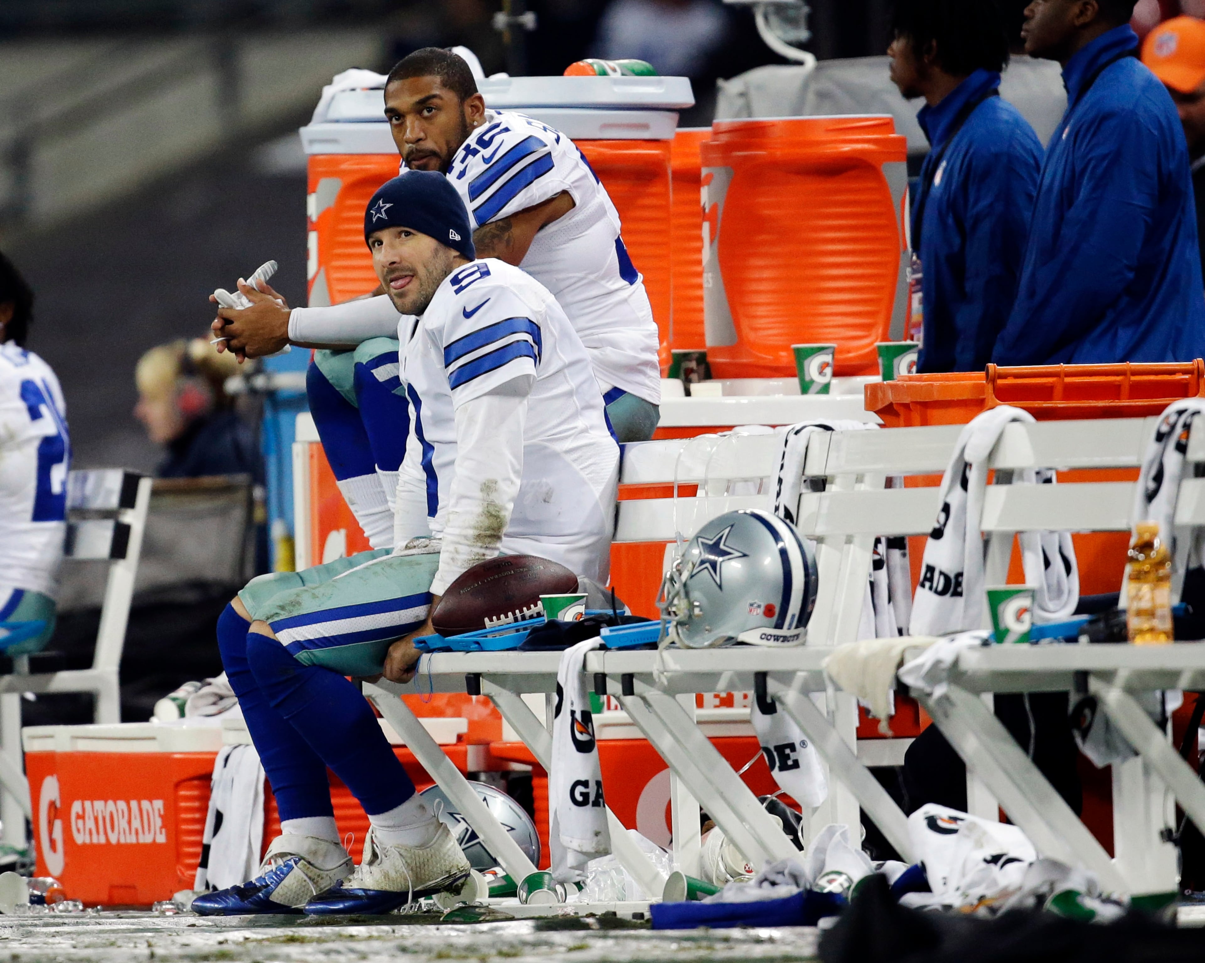 Dallas Cowboys quarterback Tony Romo sits on the side lines with Orlando Scandrick (32) during the second half of an NFL football game against the Jacksonville Jaguars at Wembley Stadium, London, Sunday, Nov. 9, 2014. The Cowboys defeated the Jaguars 31-17. (AP Photo/Matt Dunham)