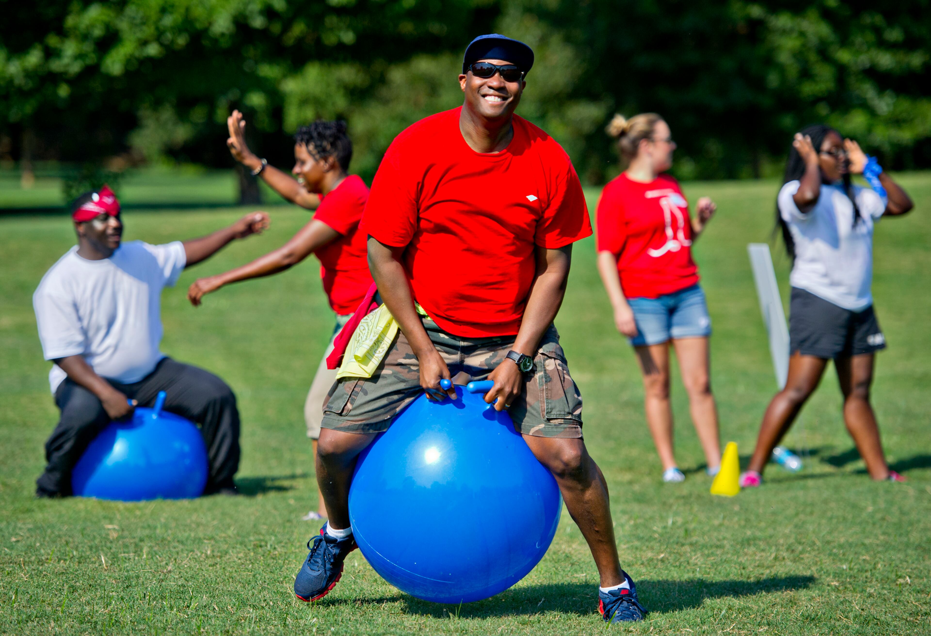 Neil Chester (center) bounces on a ball while participating in a relay race during the Boys & Girls Clubs of America's Day for Kids at Piedmont Park in Atlanta on Saturday, September 7, 2013. Day for Kids is a national initiative to raise awareness for critical issues facing young men and women. With more than a decade of tradition, Day for Kids invites adults to act like kids again by participating in field day events such as relay races, dodge ball, tug of war and lots of other activities. JONATHAN PHILLIPS / SPECIAL