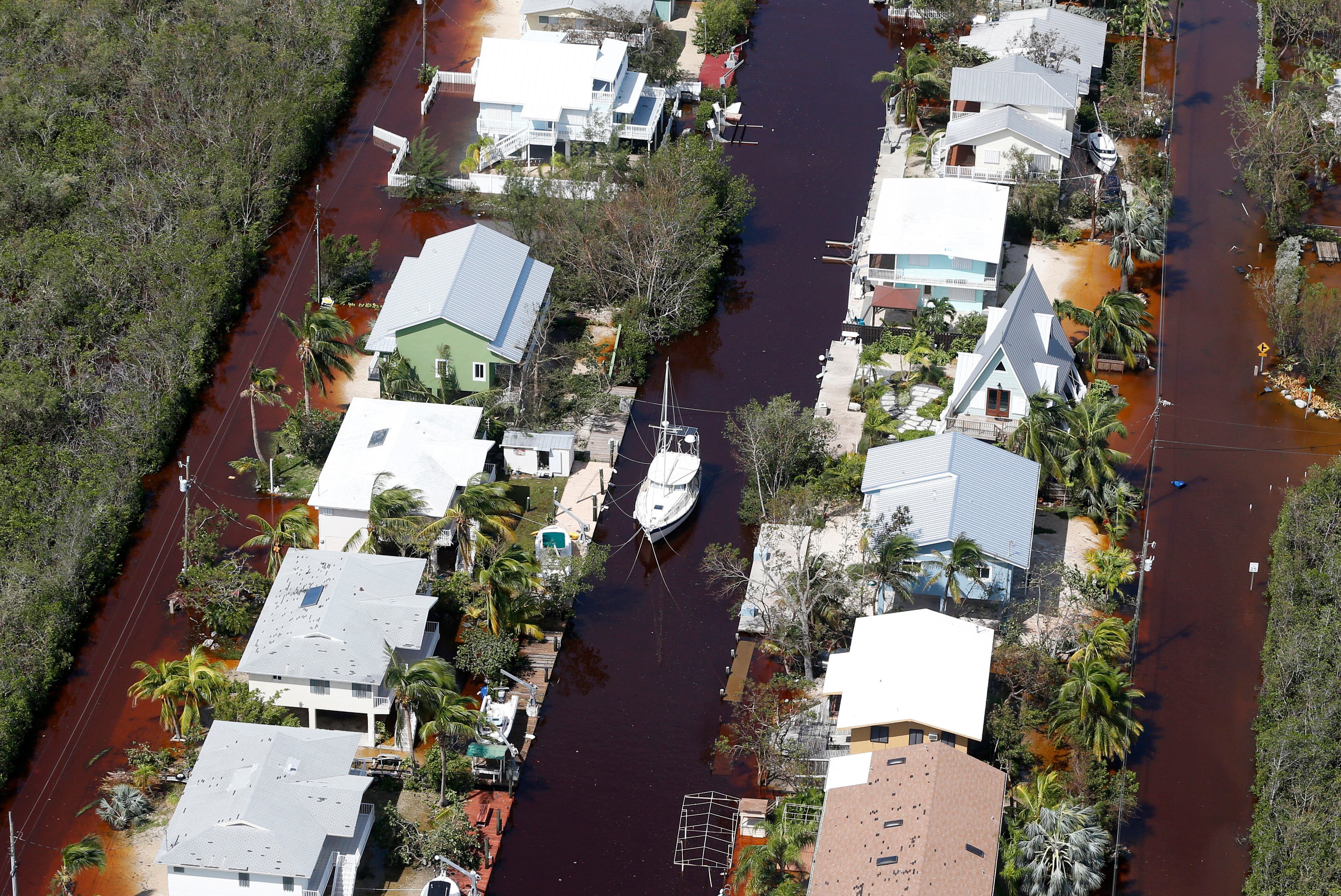 A boat lies secured in a canal between homes and flooded streets in the aftermath of Hurricane Irma, Monday, Sept. 11, 2017, in Key Largo, Fla. (AP Photo/Wilfredo Lee)