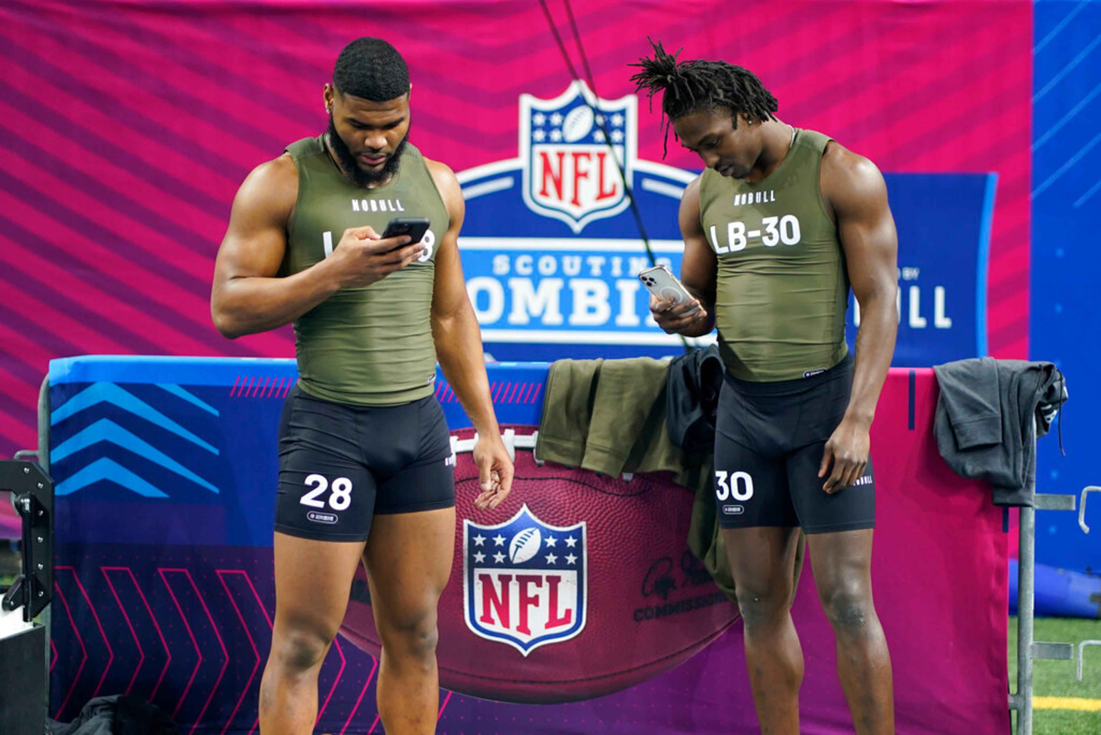 Clemson linebacker Trenton Simpson, left, and Georgia Tech linebacker Charlie Thomas checks their phones during the NFL football scouting combine in Indianapolis, Thursday, March 2, 2023. (AP Photo/Darron Cummings)