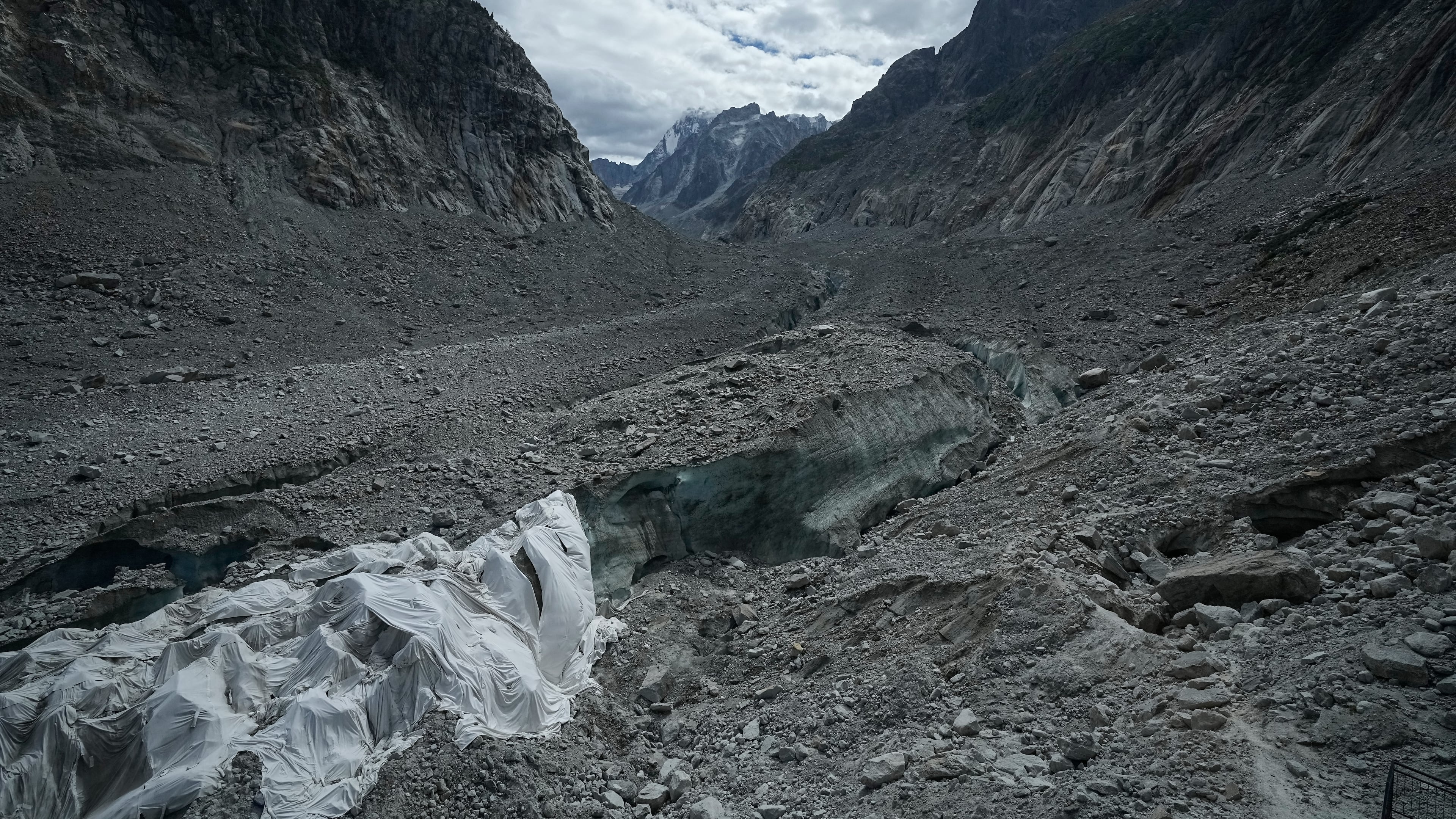 Tarpaulins cover the ice cave of the 'Mer de Glace' glacier to prevent it from melting, at the Montenvers station in Chamonix, France, Saturday, Sept. 5, 2026. (AP Photo/Laurent Cipriani)