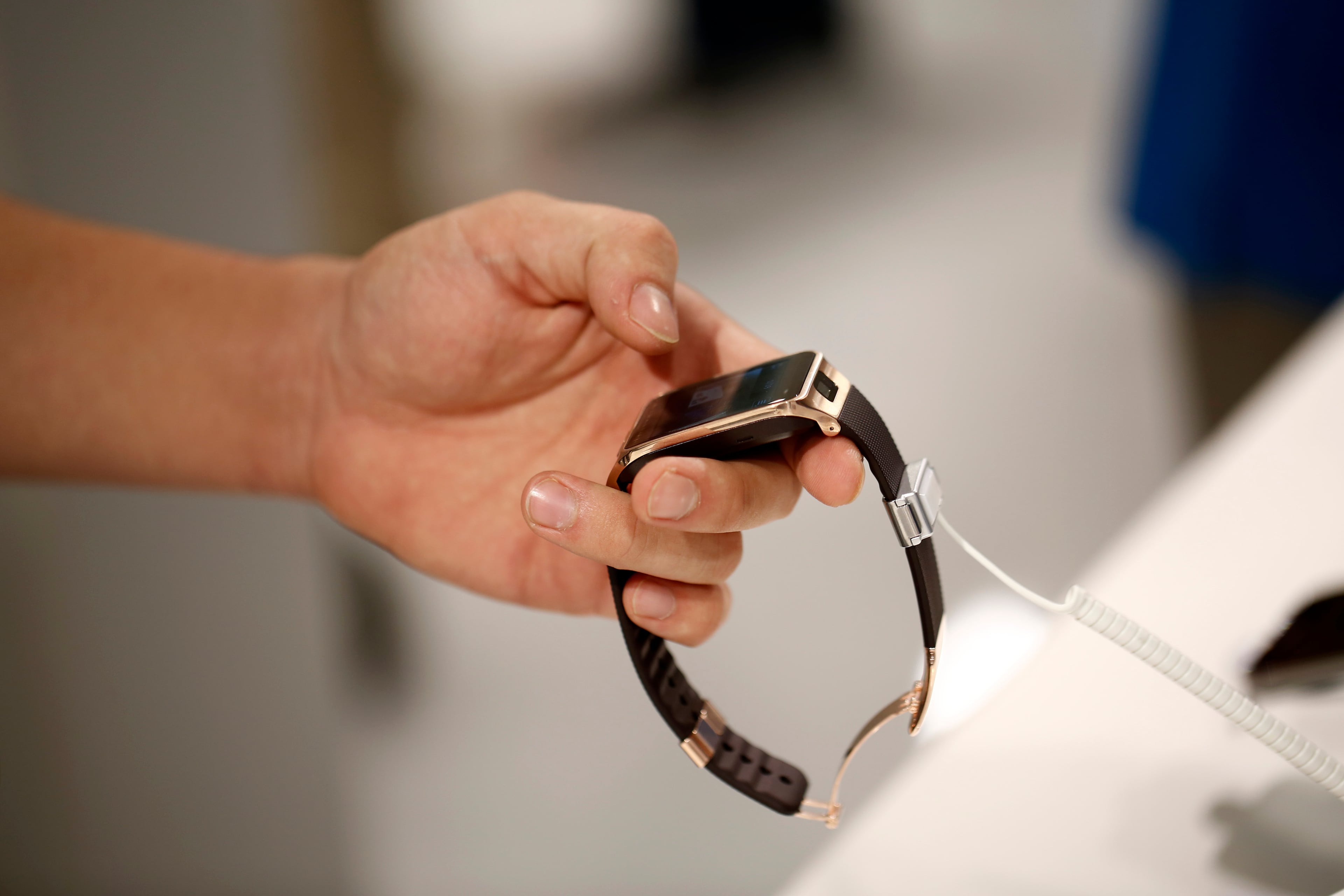 An attendee looks closely at the display screen of a Galaxy Gear 2 smartwatch at the Samsung Electronics Co. pavilion on day two of the Mobile World Congress in Barcelona, Spain, on Tuesday, Feb. 25, 2014. Top telecommunication managers will rub shoulders in Barcelona this week at the Mobile World Congress, Monday, Feb. 24 - 27, a traditional venue for showcasing the latest products for dealmaking. Photographer: Simon Dawson/Bloomberg