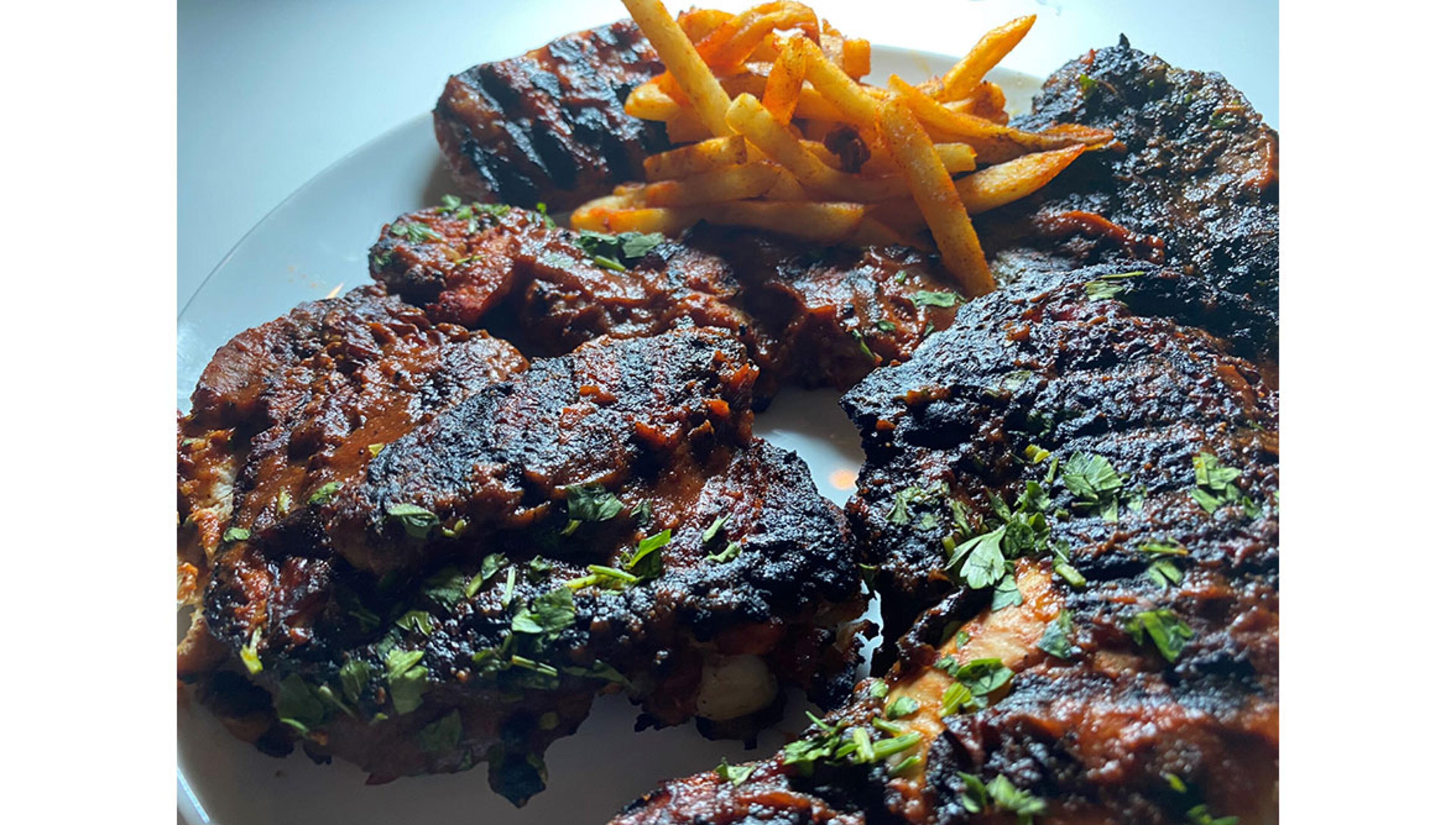 The Asado Mixto platter from Elsewhere Brewing in Grant Park includes grilled chicken, chorizo, beef, and guava shrimp, with sauces and fries. /
Bob Townsend for the Atlanta Journal-Constitution