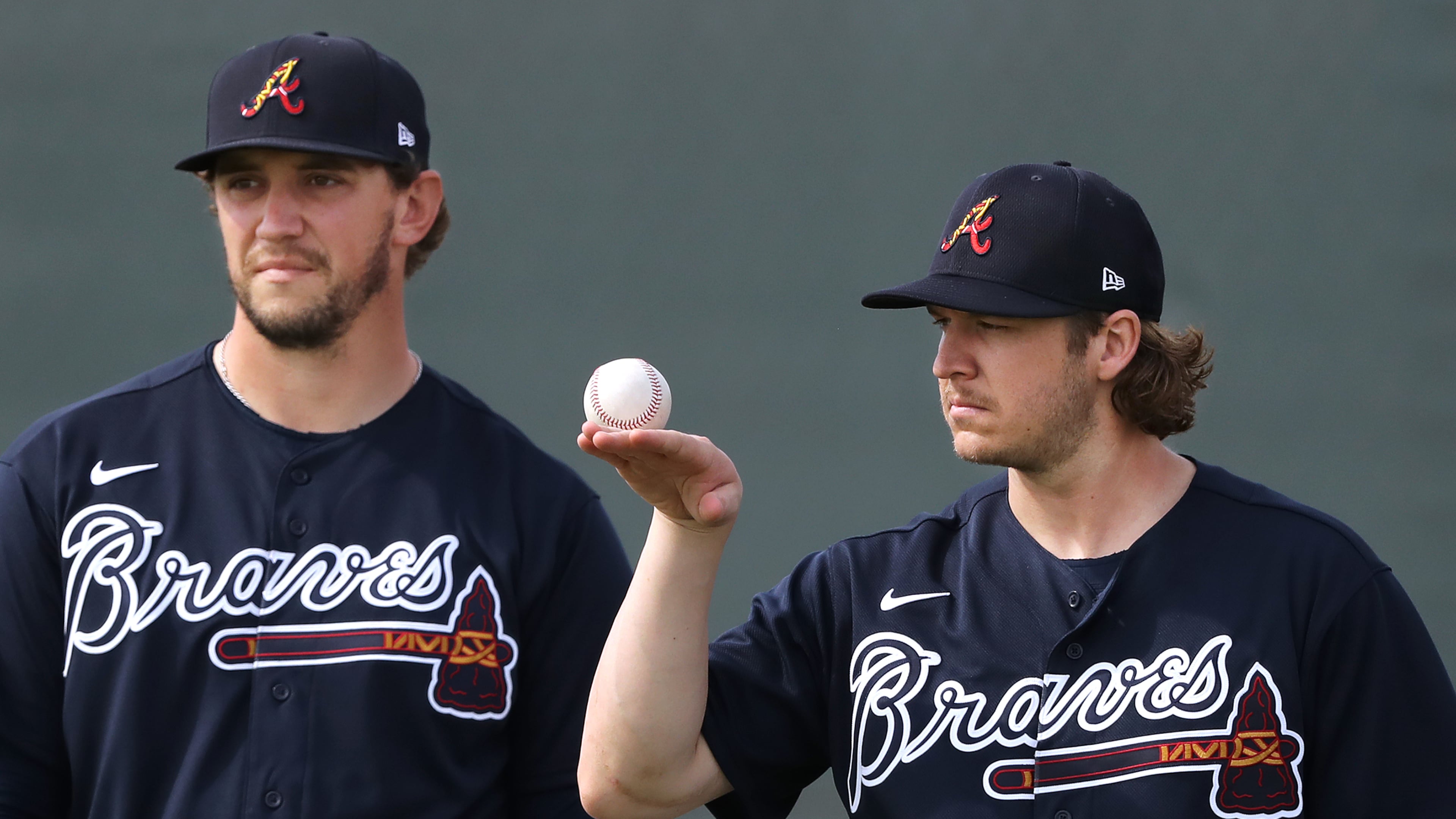 Braves pitcher Jacob Webb (right) balances a baseball while loosening up his arm with Patrick Weigel during spring training on Friday, Feb. 14, 2020, in North Port. Curtis Compton ccompton@ajc.com