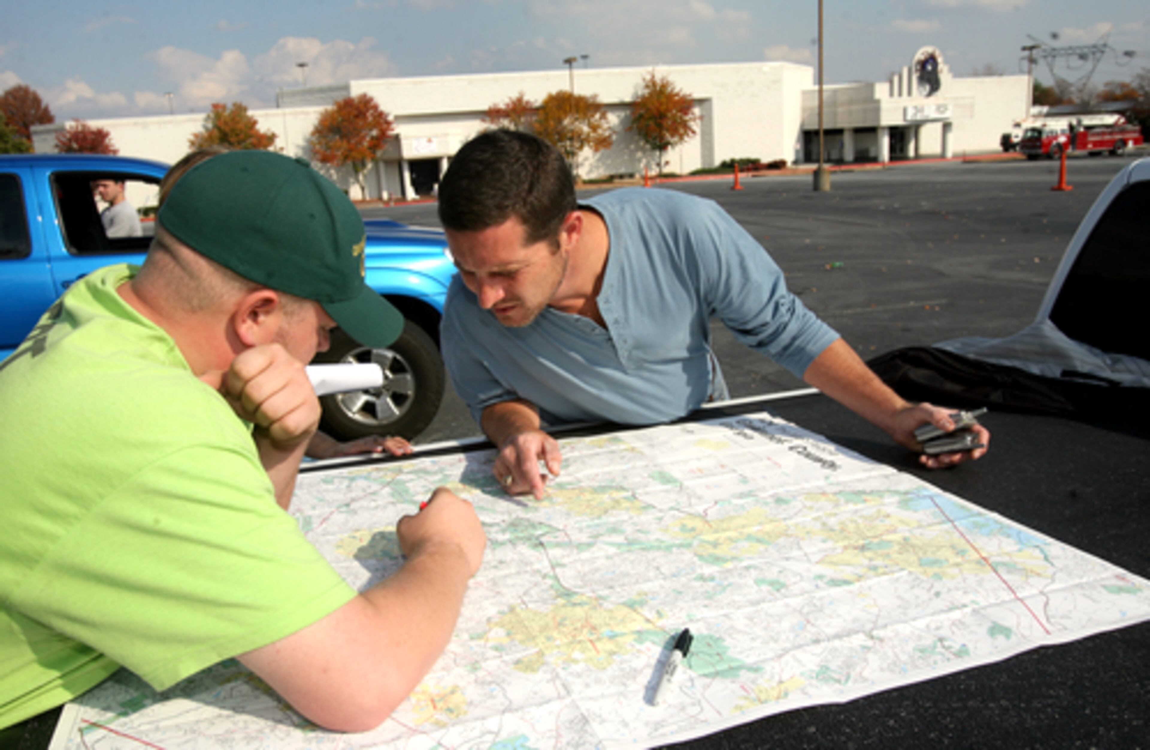 During the November search Steven Wilson, of Snellville (center) pores over a map of Duluth with friend Chris Jones, of Buford, as they look for Justin.