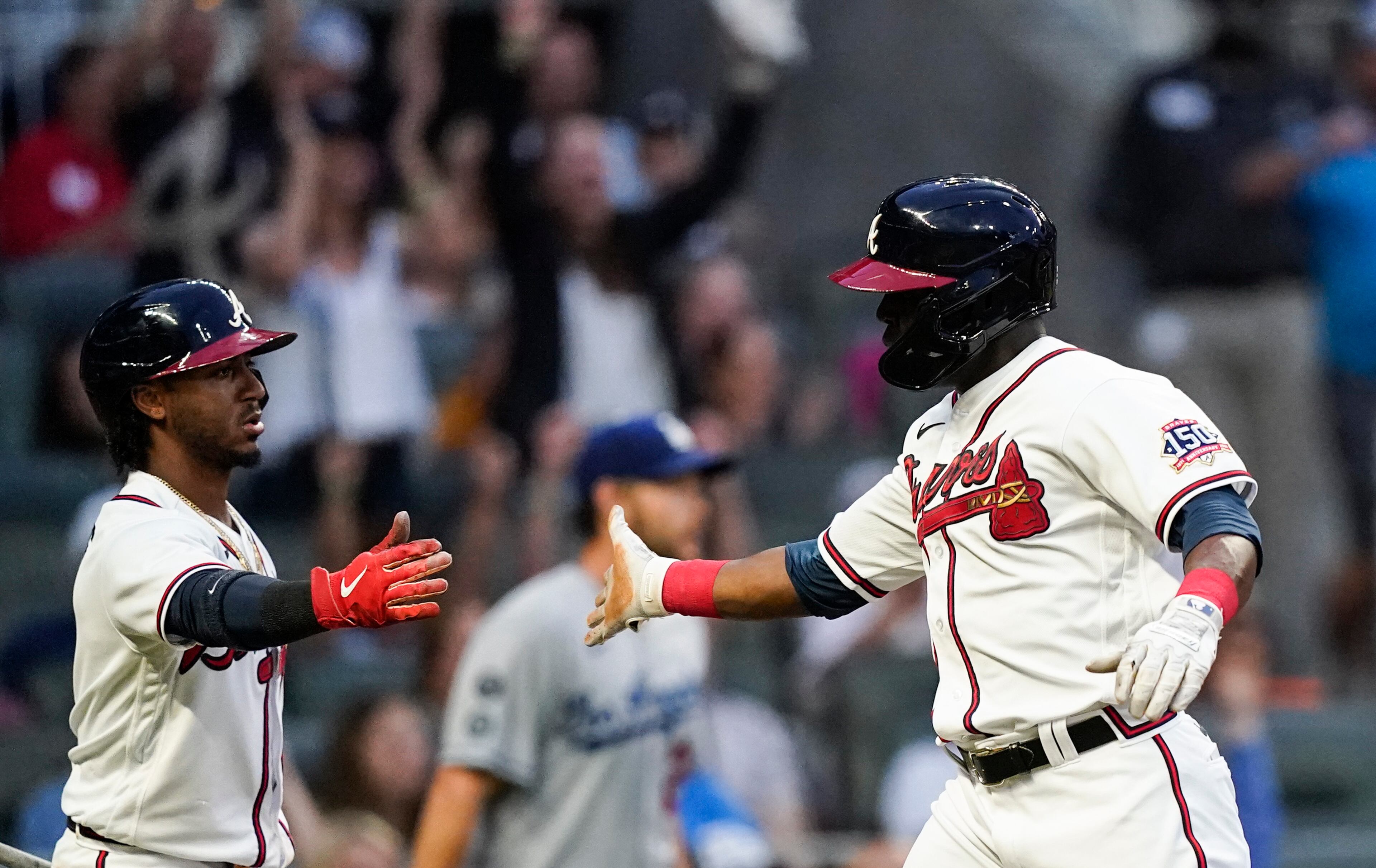 Atlanta Braves' Guillermo Heredia, right, celebrates with Ozzie Albies, left, after scoring in the third inning of a baseball game against the Los Angeles Dodgers, Saturday, June 5, 2021, in Atlanta. (AP Photo/Brynn Anderson)